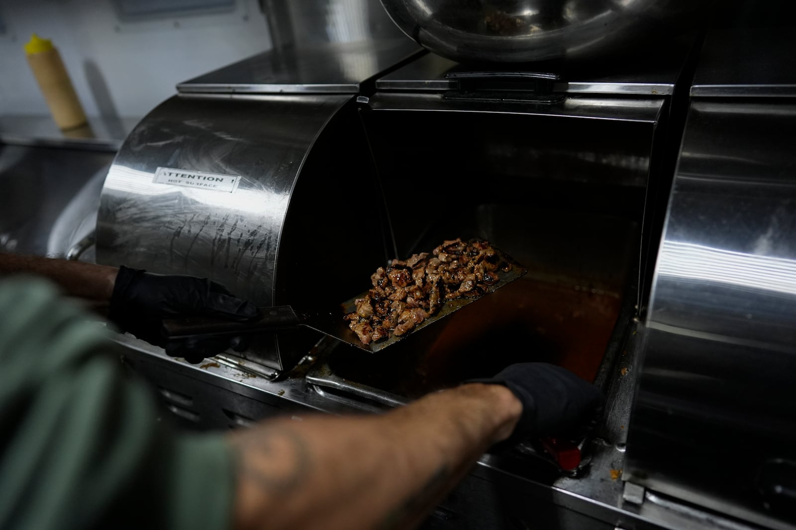 World Central Kitchen Chef Corp member Daniel Shemtob cooks meat for burritos in his food truck, The Lime Truck, for Eaton Fire first responders at the Rose Bowl Stadium, Wednesday, Jan. 15, 2025, in Pasadena, Calif. (AP Photo/Carolyn Kaster)