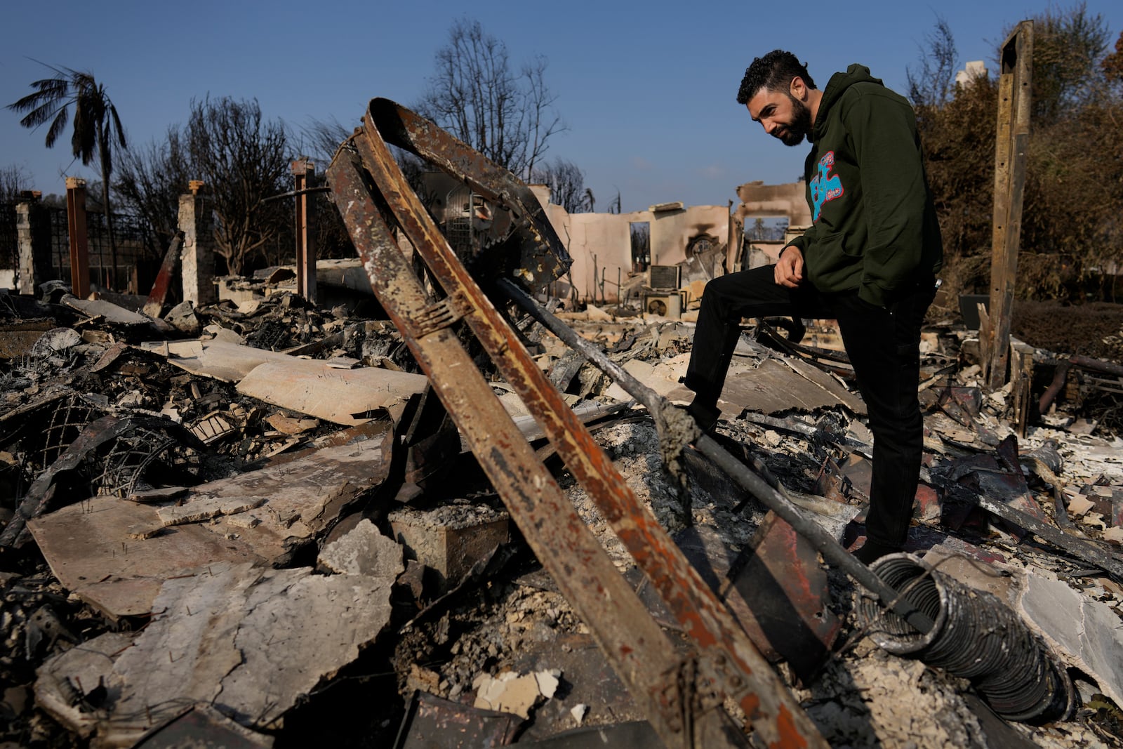 World Central Kitchen Chef Corp member Daniel Shemtob looks at the rubble that was once the garage of his home destroyed by the Palisades Fire, Sunday, Jan. 19, 2025, in the Pacific Palisades neighborhood of Los Angeles, Calif. (AP Photo/Carolyn Kaster)