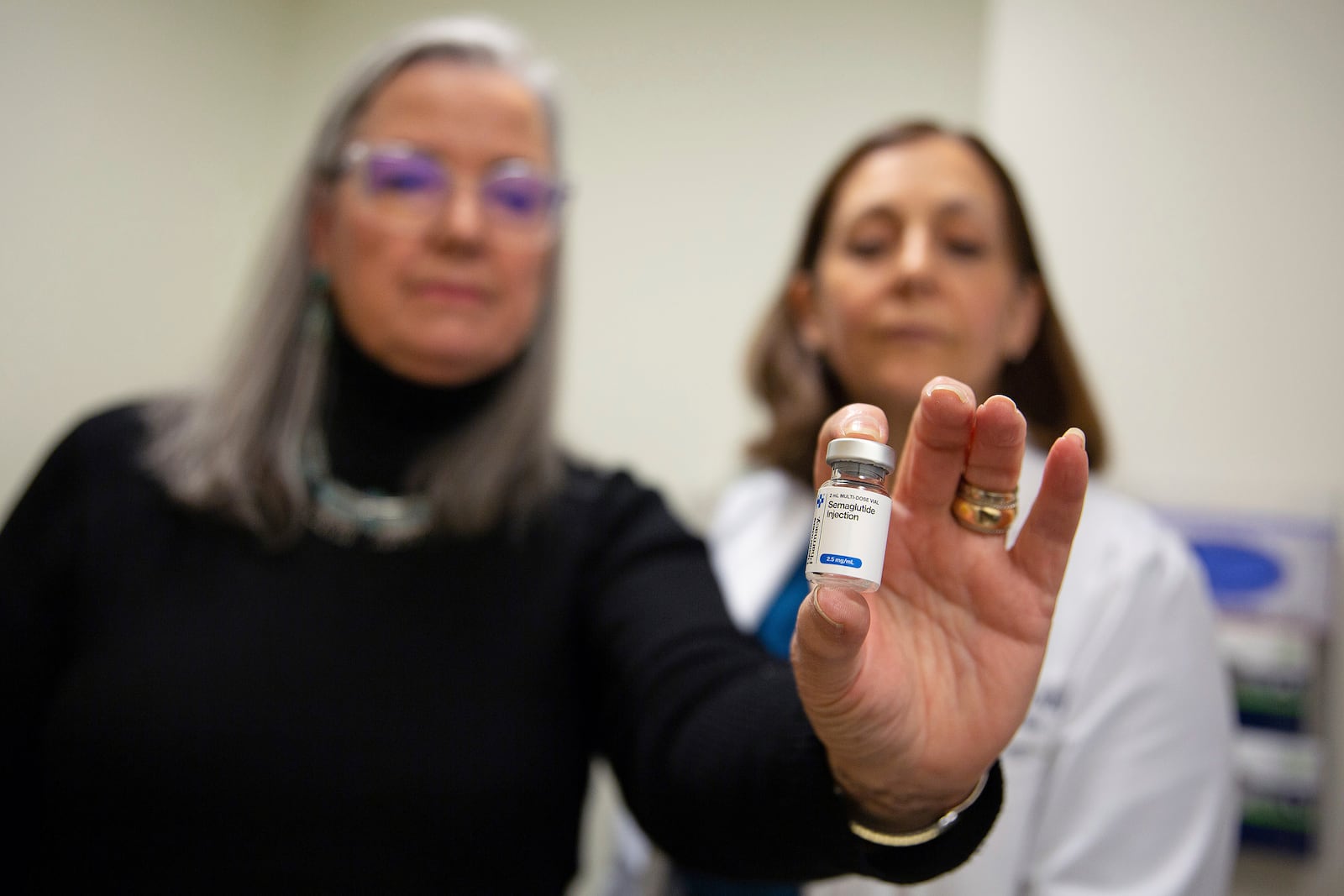 Patient Lory Osborn (left) holds Semaglutide used in replacement of her Wegovy treatment with Dr. Laura Davisson, director of the Medical Weight Management at West Virginia University in Morgantown, W.Va., Monday, Dec. 2, 2024. (AP Photo/Kathleen Batten)