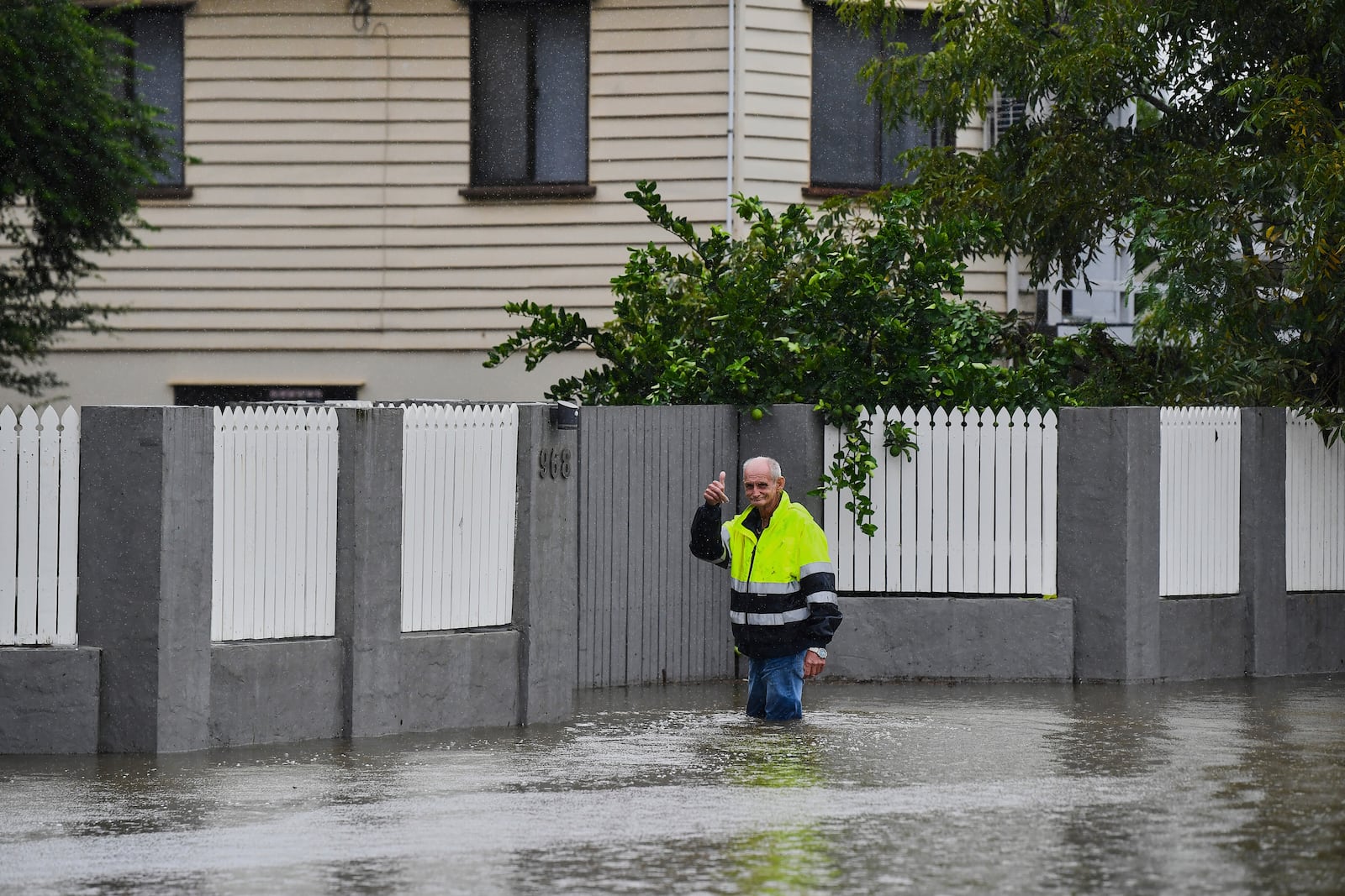 Resident Bruce Maddox walks back through flood waters to his home in the Brisbane suburb of Oxley, Australia, Monday, March 10, 2025. (Jono Searle/AAP Image via AP)