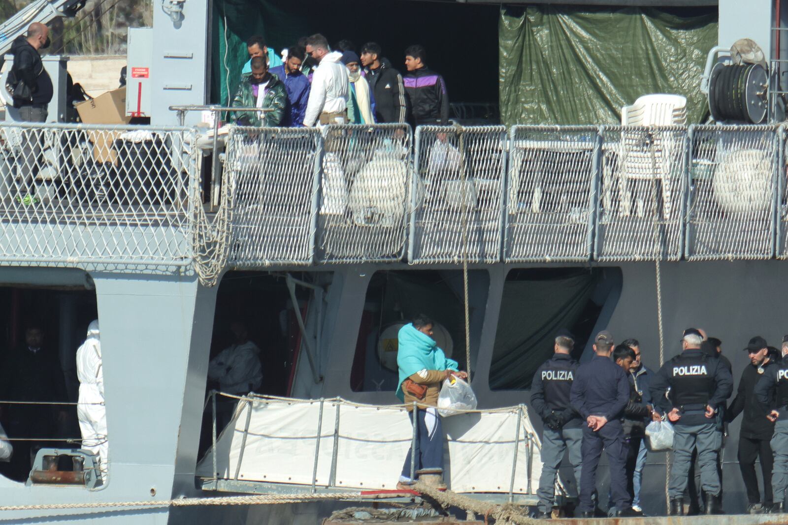 Migrants disembark an Italian Navy ship, as Italy sent 49 people to Albania for processing following earlier court rejections to Albania, in Shengjin, northwestern Albania, Tuesday, Jan. 28, 2025. (AP Photo/Vlasov Sulaj)