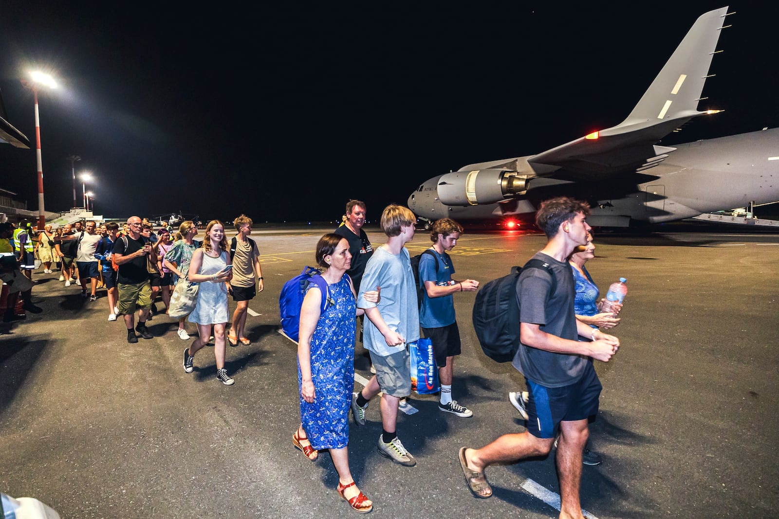 In this photo released by Australian Department of Defence, Australian citizens board a Royal Australian Air Force aircraft for a flight home from Bauerfield International Airport, Port Vila, Vanuatu, Wednesday, Dec. 18, 2024 following a powerful earthquake that struck just off the coast of Vanuatu in the South Pacific Ocean. (CPL Adam Abela/Australian Department of Defence via AP)