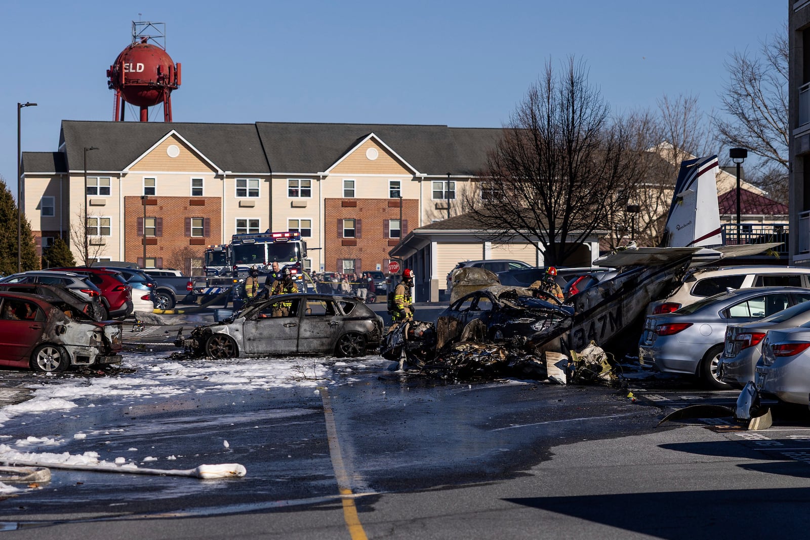 First responders work the scene after a plane crashed in the parking lot of a retirement community in Manheim Township, Pa., Sunday, March 9, 2025. (Logan Gehman/LNP/LancasterOnline via AP)