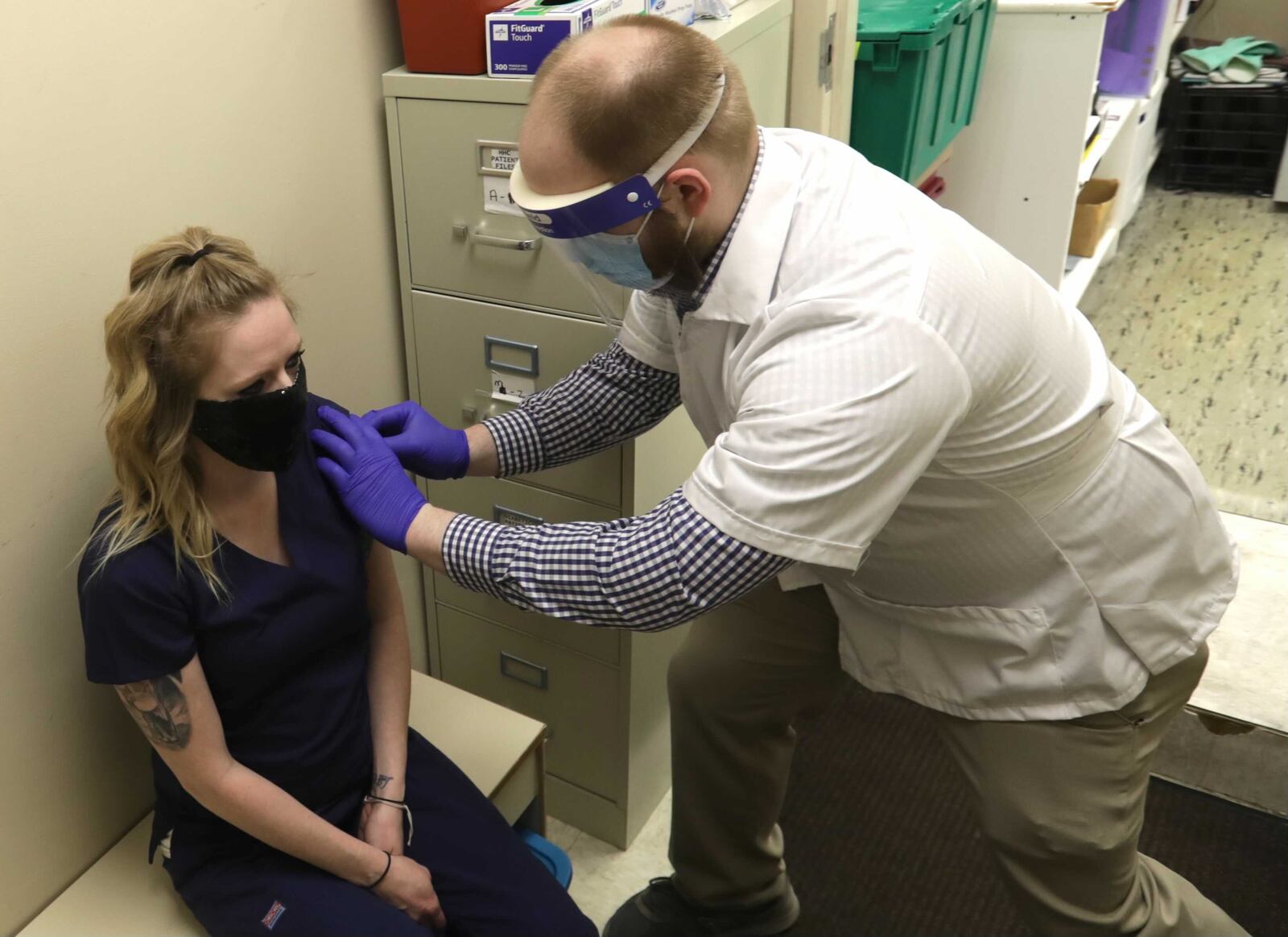 Andrew Hoffman, a pharmacist at Discount Drug Mart in Enon, gives Jennifer Boswell a flu shot at the pharmacy Thursday. BILL LACKEY/STAFF