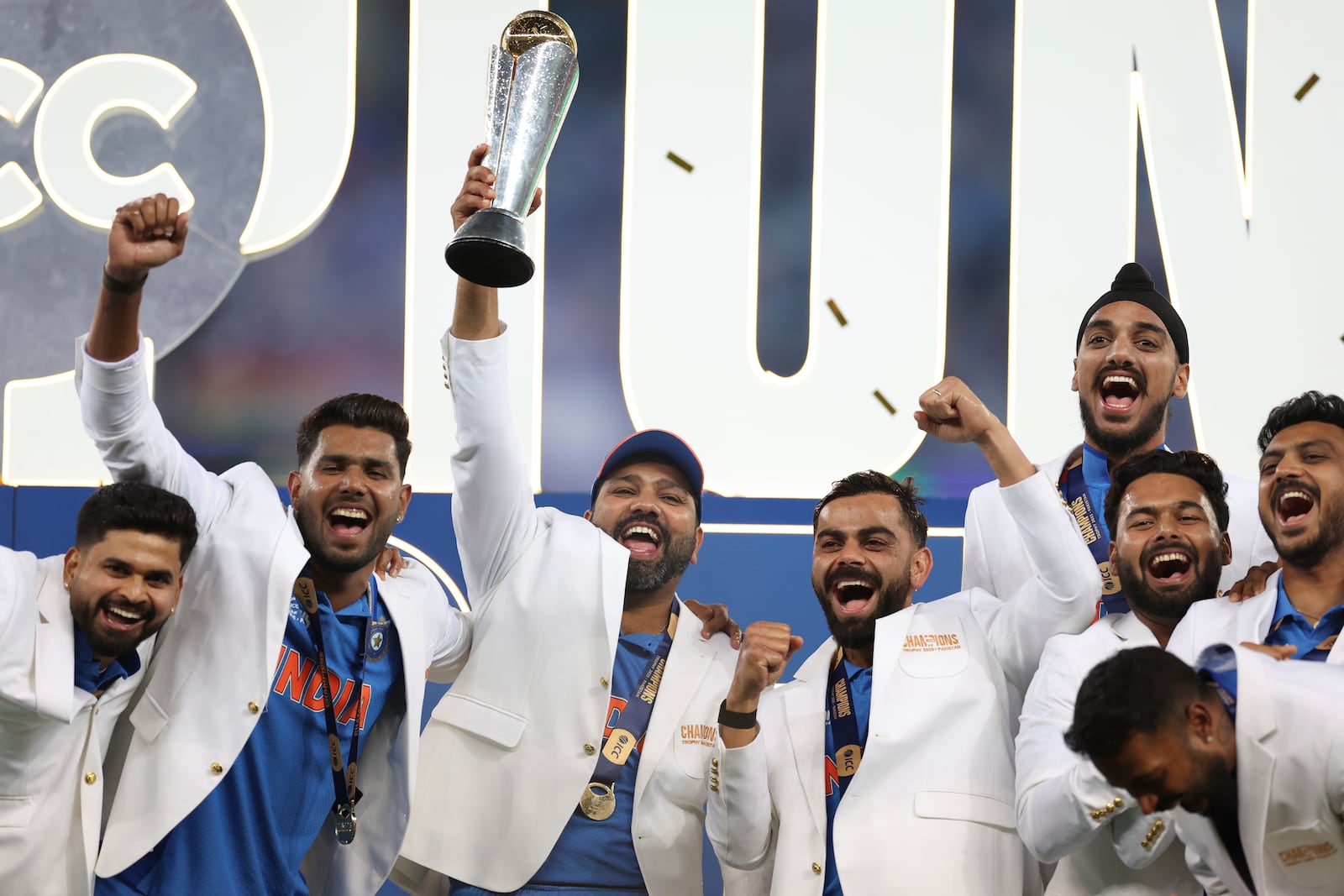 India's captain Rohit Sharma, third left, and teammates celebrate with the winners trophy on the podium after defeating New Zealand in the final cricket match of the ICC Champions Trophy at Dubai International Cricket Stadium in Dubai, United Arab Emirates, Sunday, March 9, 2025. (AP Photo/Christopher Pike)