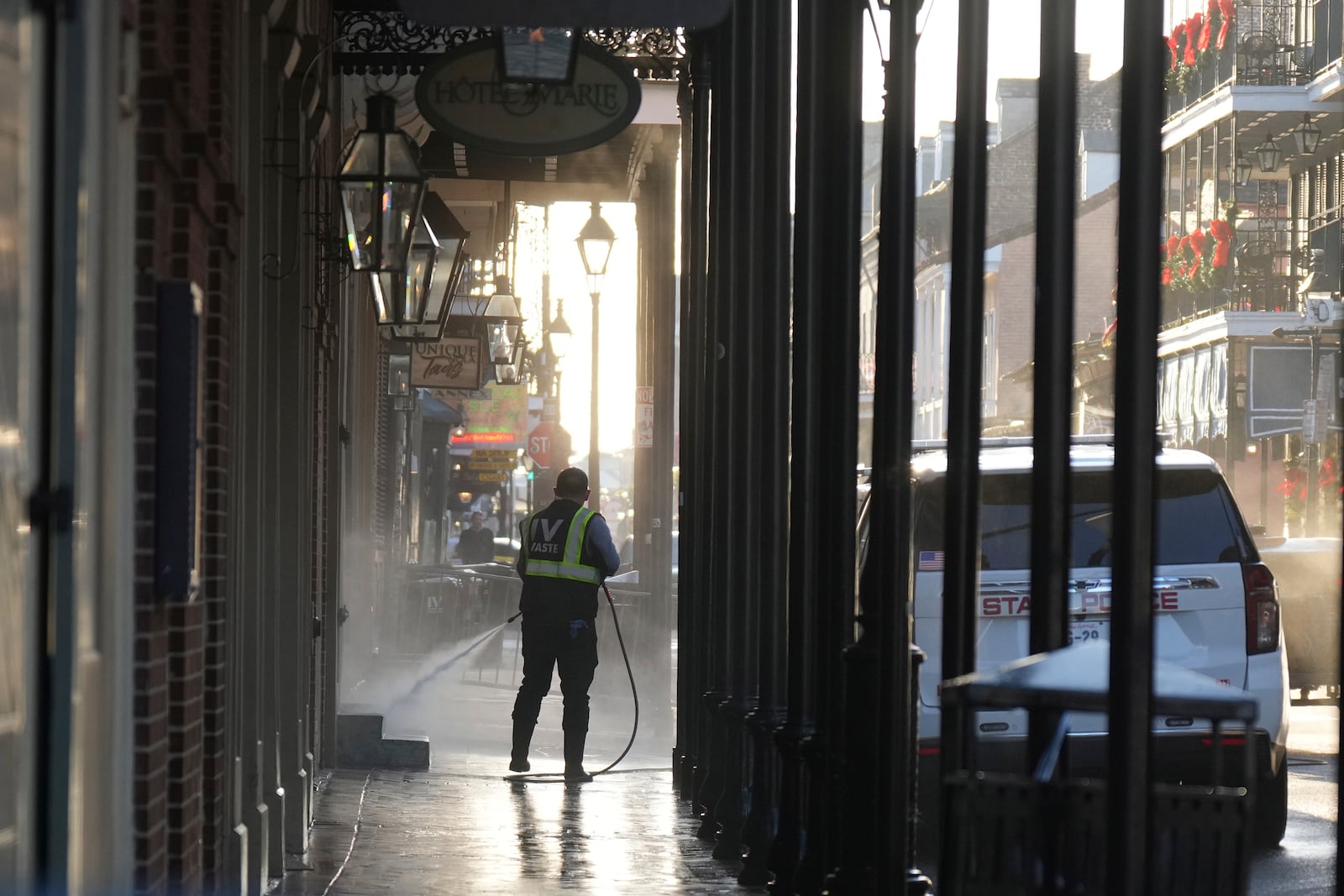 A man uses a power washer on Toulouse street a day after a vehicle was driven into a crowd on New Orleans' Canal and Bourbon streets, Thursday, Jan. 2, 2025. (AP Photo/George Walker IV)