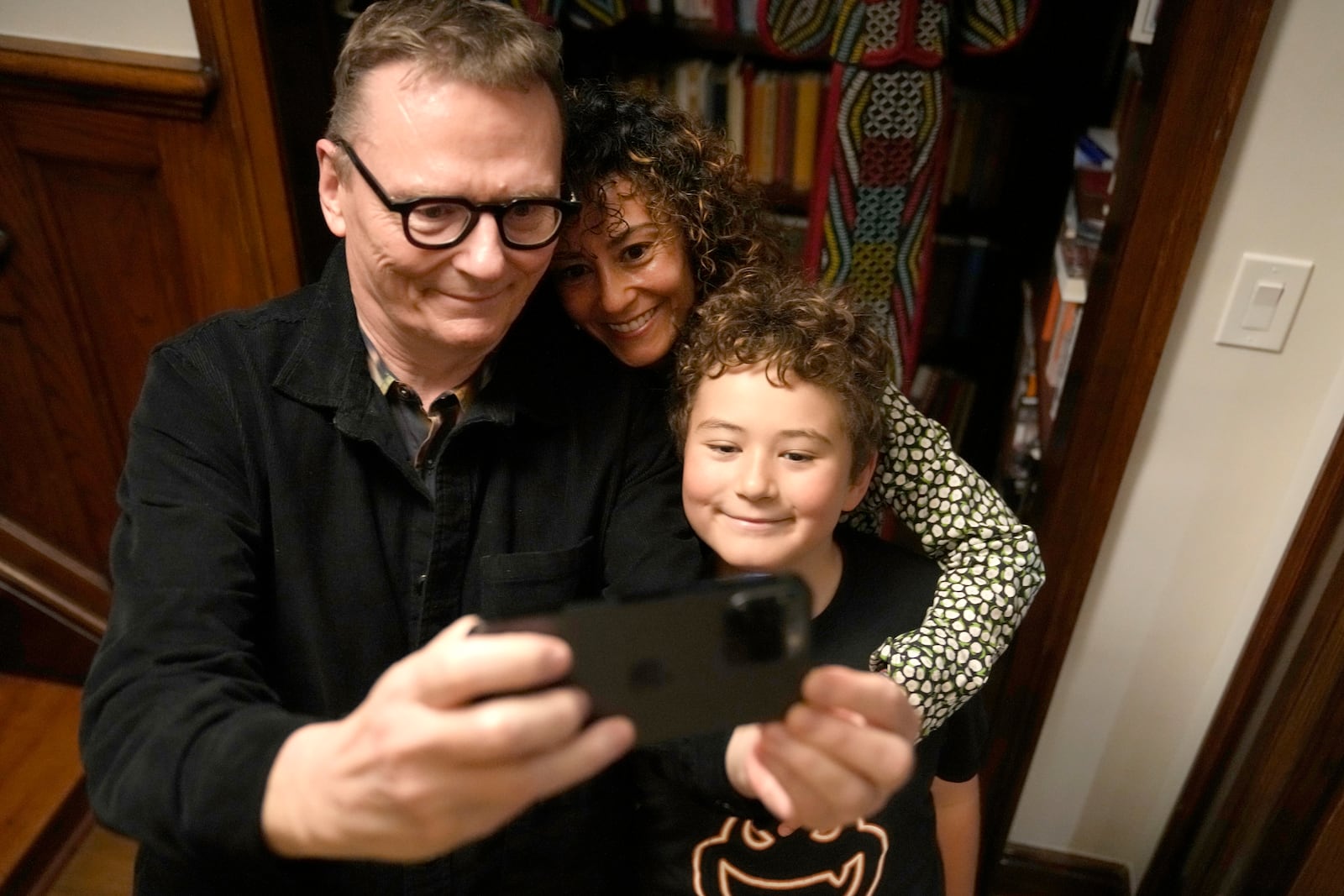 Nobel prize winner in Economics, James A. Robinson makes a selfie for the Nobel Foundation with his wife, Dr. Maria Angelica Bautista, and their son Adrian at their home in the Hyde Park neighborhood of Chicago, Monday, Oct. 14, 2024. (AP Photo/Charles Rex Arbogast)