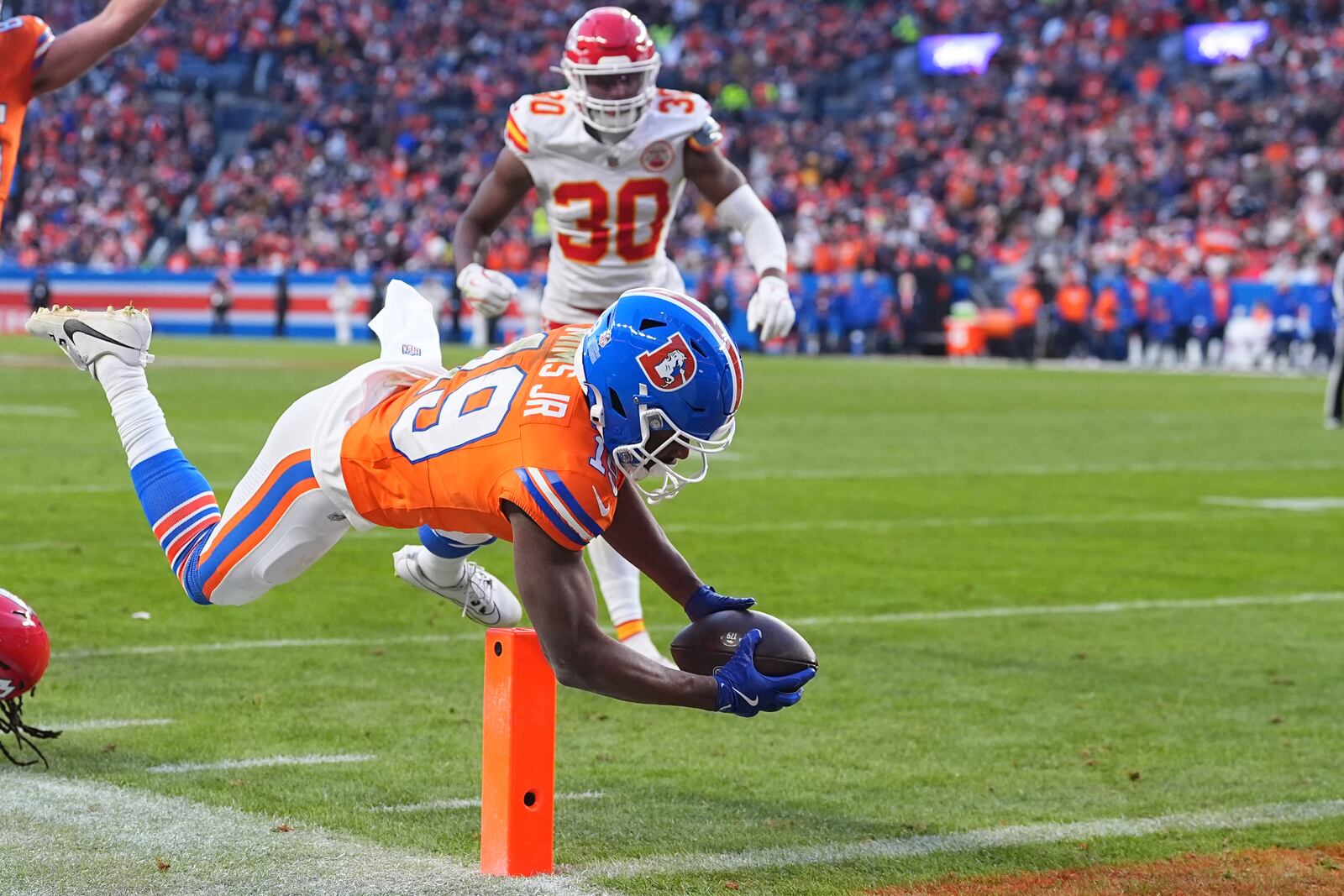 Denver Broncos wide receiver Marvin Mims Jr. (19) scores as Kansas City Chiefs cornerback Chris Roland-Wallace (30) watches during the second half of an NFL football game Sunday, Jan. 5, 2025, in Denver. (AP Photo/David Zalubowski)