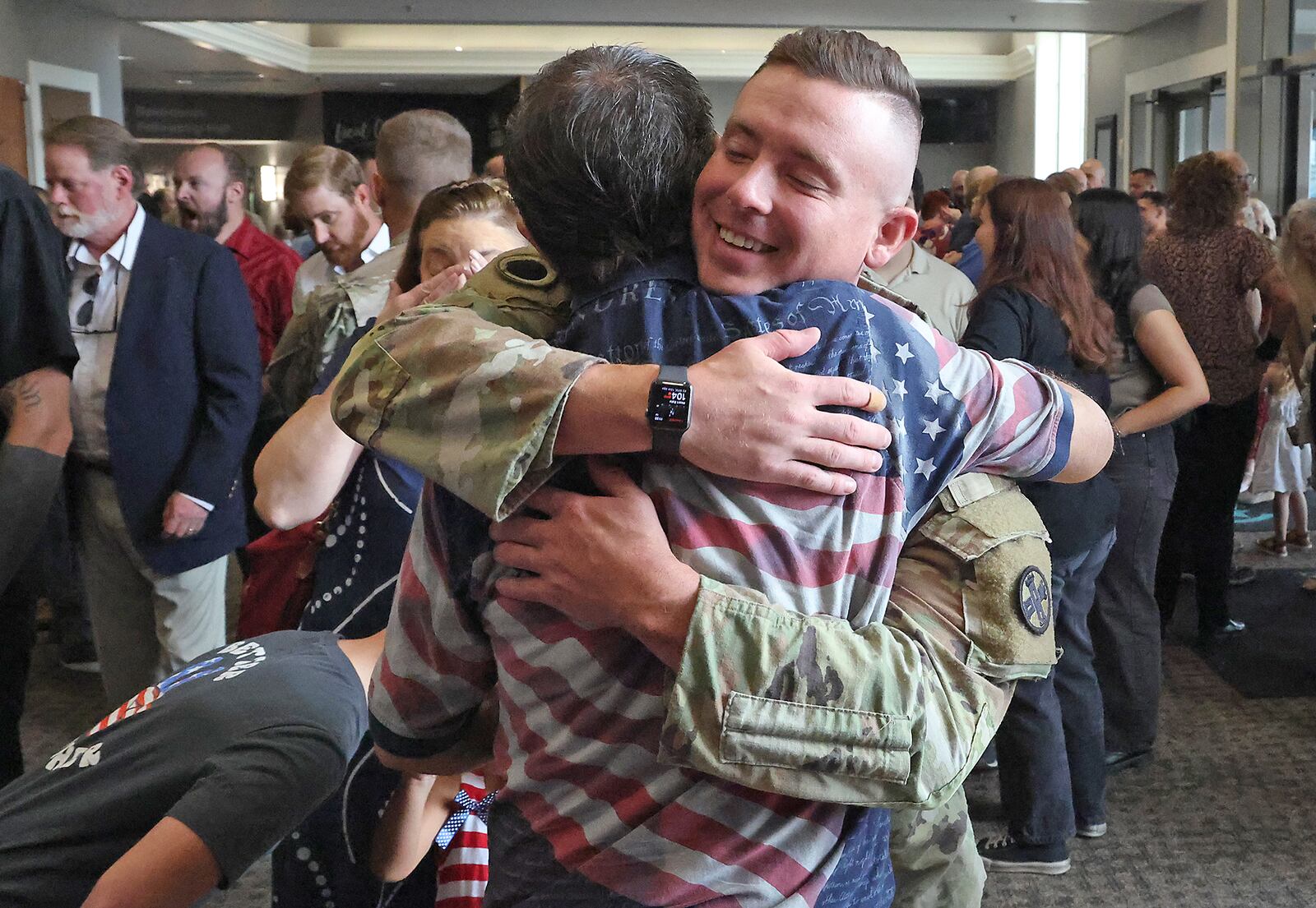 SSG Jacob East of the Ohio Army National Guard 1137th Tactical Installation Networking Enhanced Signal Company, gets a hug from his family following a Call to Duty Ceremony for the unit Saturday, August 31, 2024 at the First Christian Church in Springfield. BILL LACKEY/STAFF