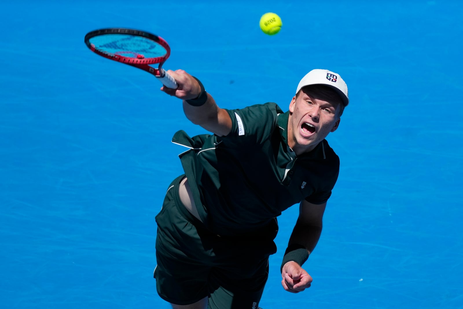 Jenson Brooksby of the U.S. serves to Taylor Fritz of the U.S. during their first round match at the Australian Open tennis championship in Melbourne, Australia, Tuesday, Jan. 14, 2025. (AP Photo/Vincent Thian)