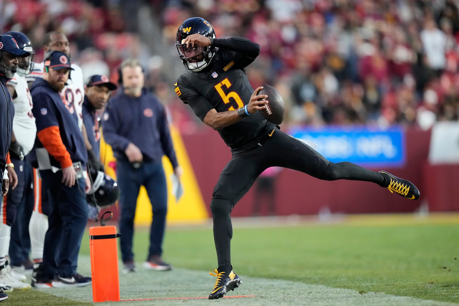 Washington Commanders quarterback Jayden Daniels (5) tries to stay in bounds in the second half of an NFL football game against the Chicago Bears Sunday, Oct. 27, 2024, in Landover, Md. (AP Photo/Stephanie Scarbrough)