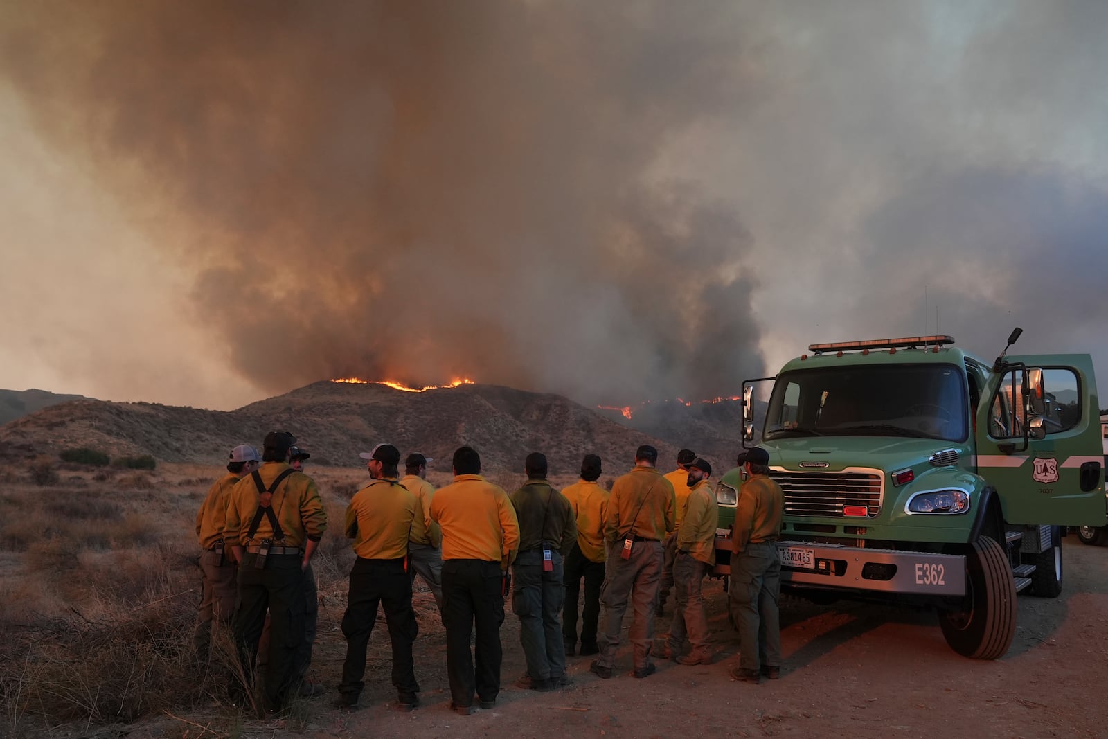 Workers monitor flames caused by the Hughes Fire is seen in Castaic, Calif., Wednesday, Jan. 22, 2025. (AP Photo/Marcio Jose Sanchez)