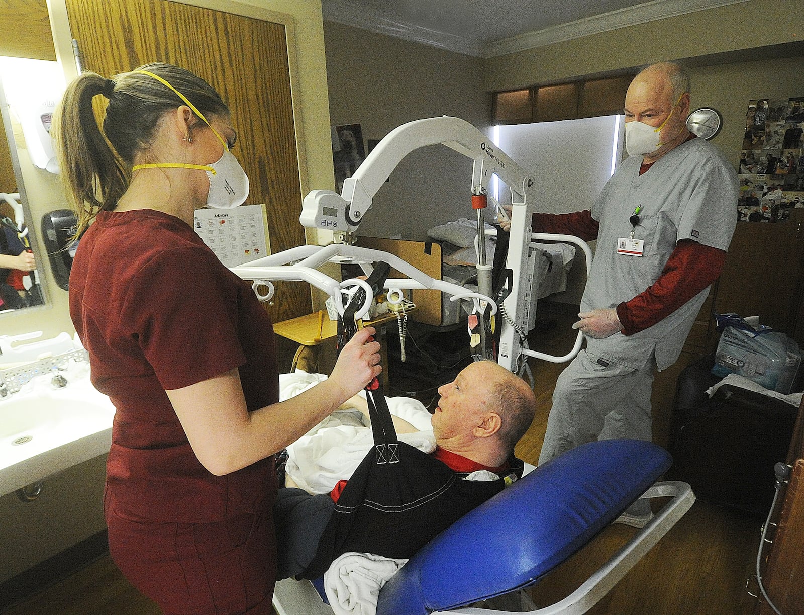 Staff members Sabrina Hall, STNA, left and Kent Little, STNA, at the Friends Care Community Facility in Yellow Springs assist resident Woody Wilson, Monday Feb. 19, 2024. The Friends Care Community facility was ranked the highest for resident satisfaction in Greene County following a recent survey conducted by the state. MARSHALL GORBY\STAFF
