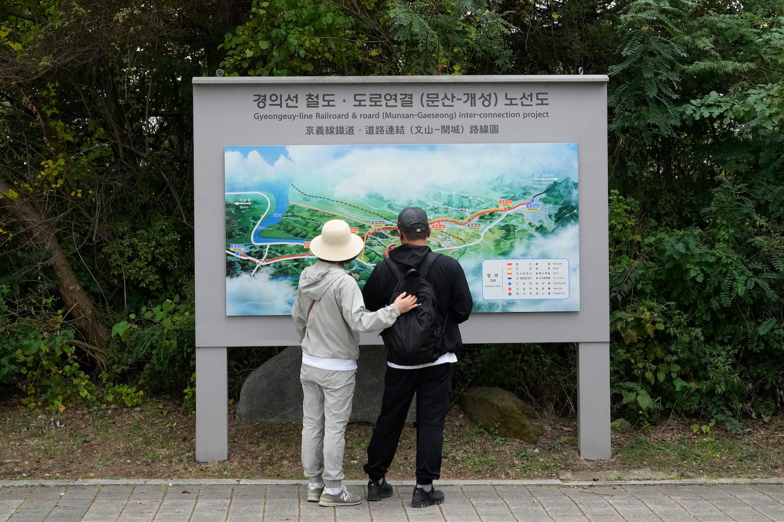 South Korean visitors look at a map which shows a border area of two Koreas with a railroad line between Munsan city in south and Kaesong in north, at the Imjingak Pavilion in Paju, South Korea, near the border with North Korea, Monday, Oct. 14, 2024. (AP Photo/Ahn Young-joon)