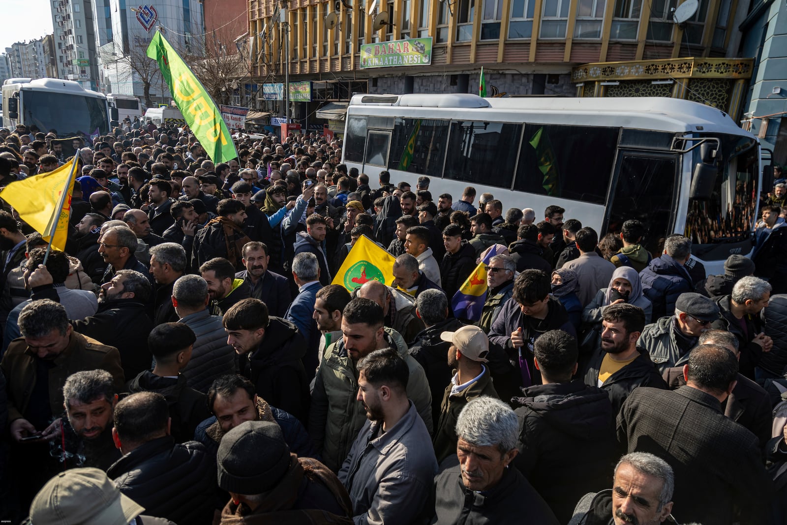 People gather to watch live on a tv screen a Pro-Kurdish Peoples' Equality and Democracy Party, or DEM, delegation members releasing an statement from the jailed leader of the rebel Kurdistan Workers' Party, or PKK, Abdullah Ocalan, in Diyarbakir, Turkey, Thursday, Feb. 27, 2025. (AP Photo/Metin Yoksu)