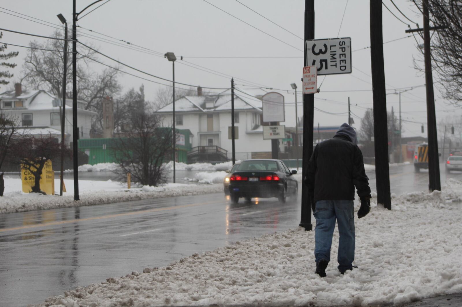 A man walks along North Main as cars drive past traveling well above the posted speed limit of 35 mph., on Feb. 20, 2019.  CORNELIUS FROLIK / STAFF