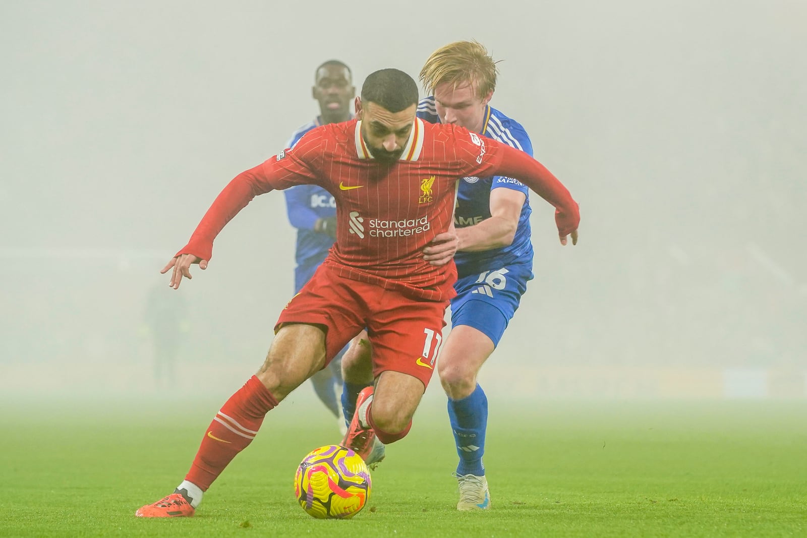 Liverpool's Mohamed Salah, front, controls a ball chased by Leicester's Victor Kristiansen during a English Premier League soccer match at the Anfield stadium in Liverpool, Thursday, Dec. 26, 2024. (AP Photo/Ian Hodgson)