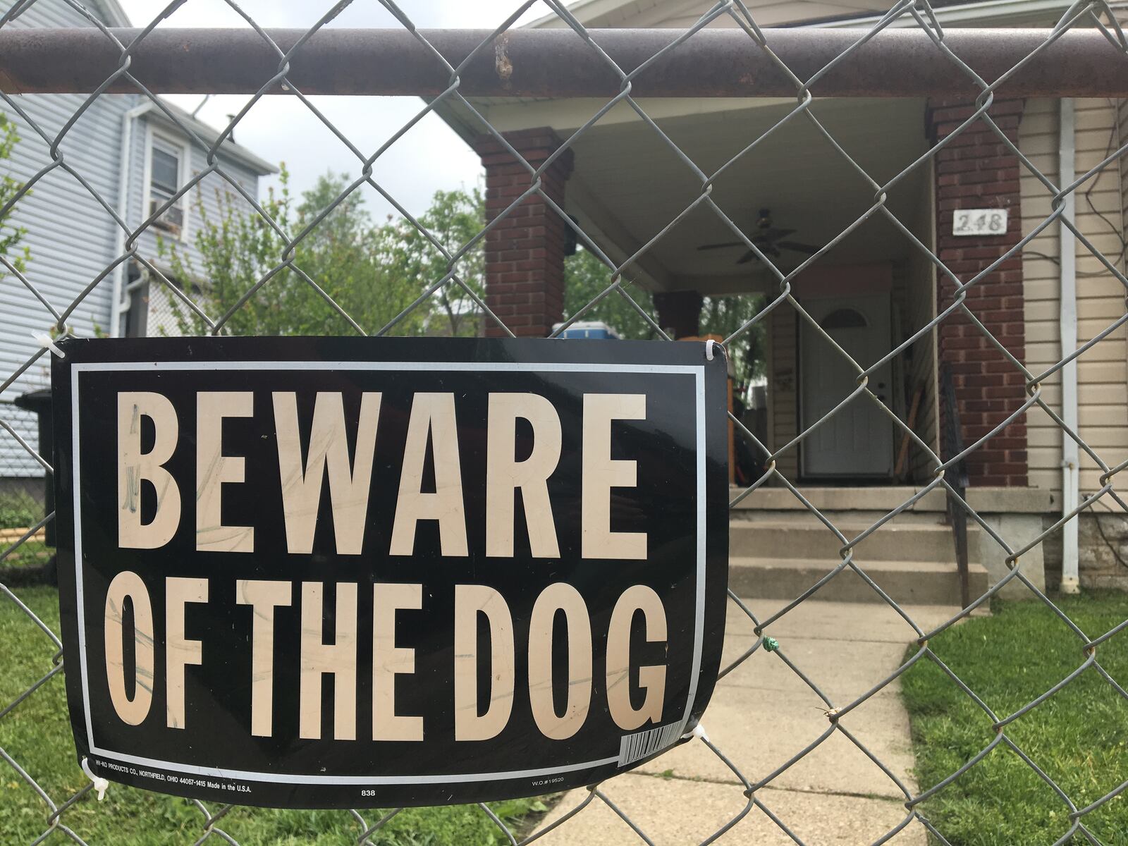 A Beware of the Dog sign on a fence outside a Dayton home. CORNELIUS FROLIK / STAFF