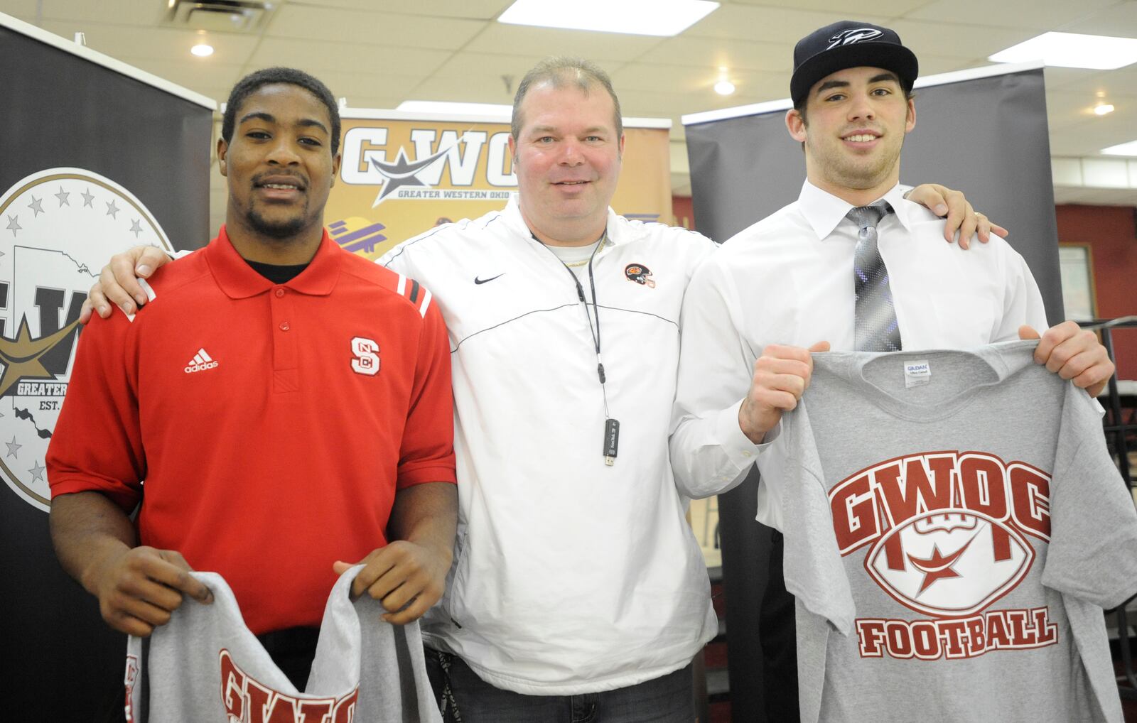 Airius Moore of Beavercreek H.S. (left), Beavers head football coach Scott Clodfelter and Beavercreek's Mike Berry ) were among those at the Greater Western Ohio Conference college football signing ceremony at the Huber Heights Athletic Foundation Center on Friday, Feb. 7, 2014. MARC PENDLETON / STAFF