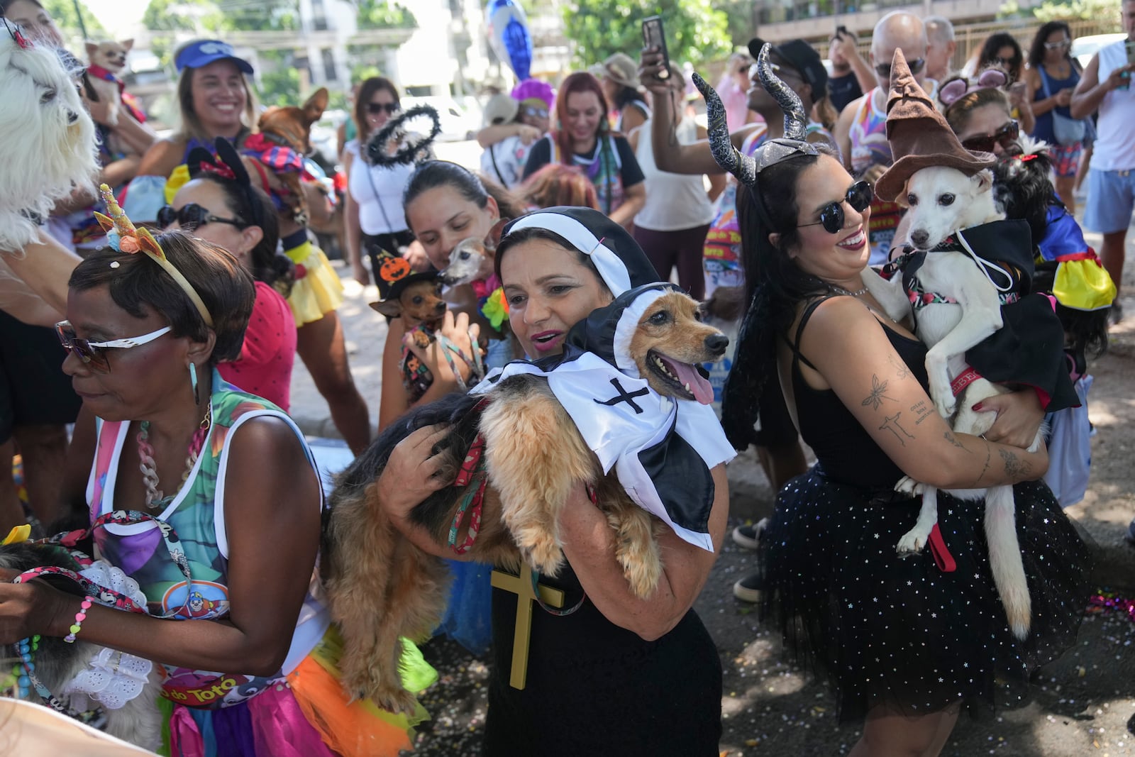 Owners and their pets take part in the "Blocao" dog carnival parade in Rio de Janeiro, Brazil, Saturday, March 1, 2025. (AP Photo/Silvia Izquierdo)