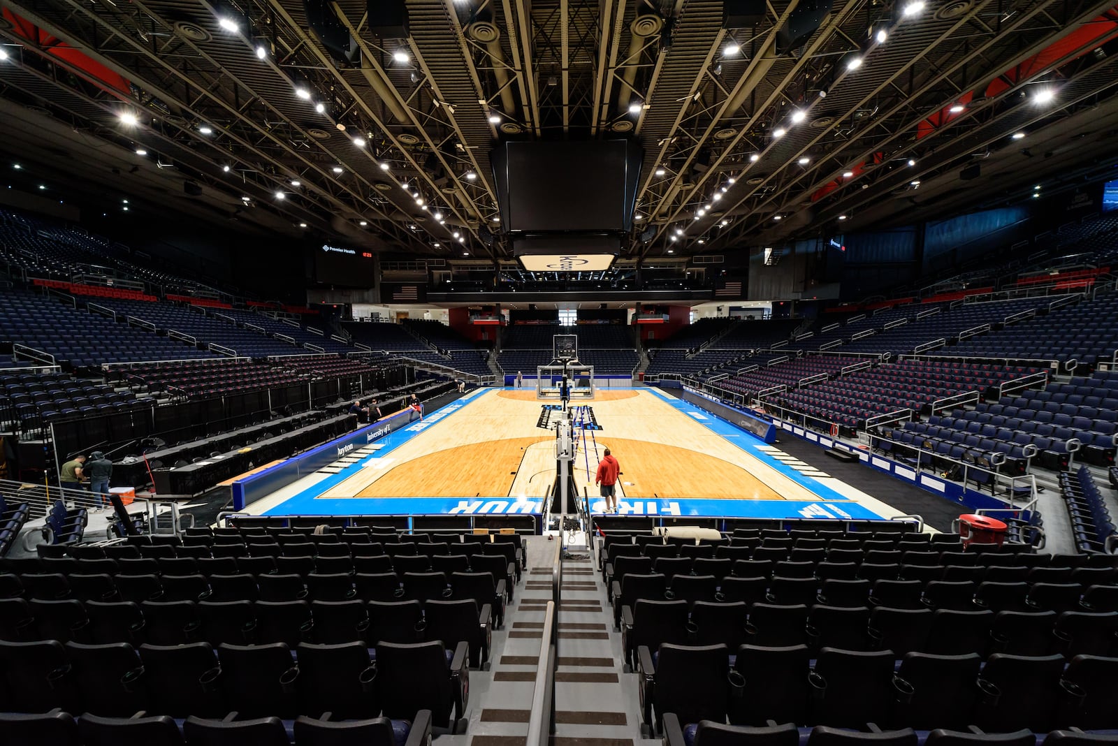 On St. Patrick's Day 2024, workers put the finishing touches on the basketball court installation for the First Four of the NCAA Division I Men’s Basketball Championship at UD Arena which will take place on March 19 & 20, 2024. TOM GILLIAM / CONTRIBUTING PHOTOGRAPHER