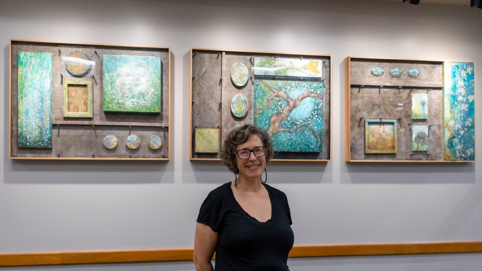 Kate Huser Santucci's three-paneled work entitled "Seasonal" is featured at the Southeast library branch. "I use repeated imagery of Sycamore trees and gardens to convey the importance of our green spaces within urban neighborhoods," she writes.