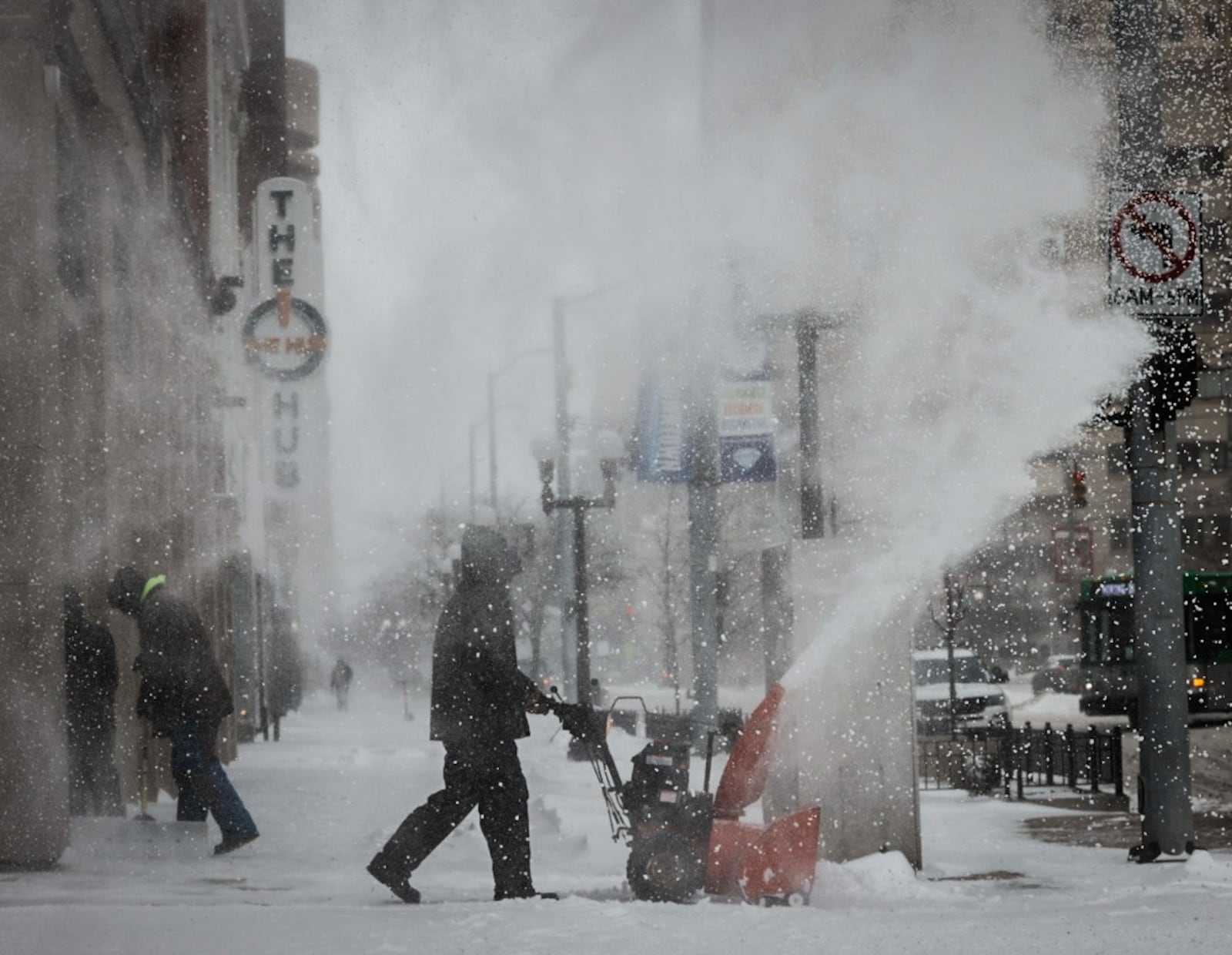 Juan Carlos blows snow on Main Street near The Hub in Dayton Friday December 23, 2022.  Jim Noelker/Staff