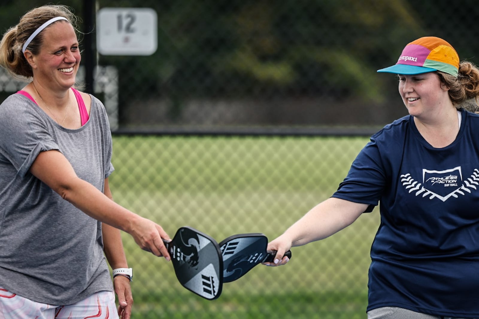 Amy Uszynski, left and Sam Whelan celebrate a score at the new J.F. Kennedy Park pickleball courts in Kettering Monday July 3, 2023. JIM NOELKER/STAFF