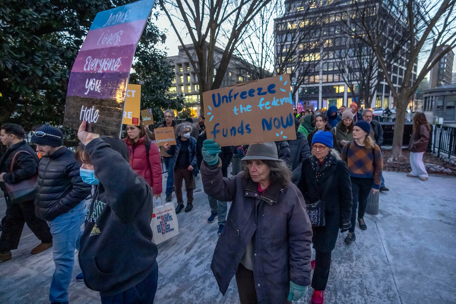 People protest against a funding freeze of federal grants and loans following a push from President Donald Trump to pause federal funding near to the White House in Washington, Tuesday, Jan. 28, 2025. (AP Photo/Ben Curtis)