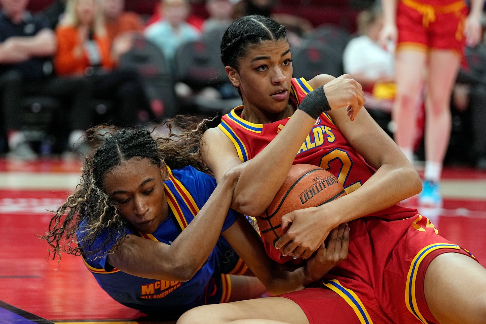 FILE - East guard Mikayla Blakes, left, and West forward Arianna Roberson (12) wrestle for a loose ball during the first quarter of the McDonald's All American girls' basketball game, April 2, 2024, in Houston. (AP Photo/Kevin M. Cox, File)