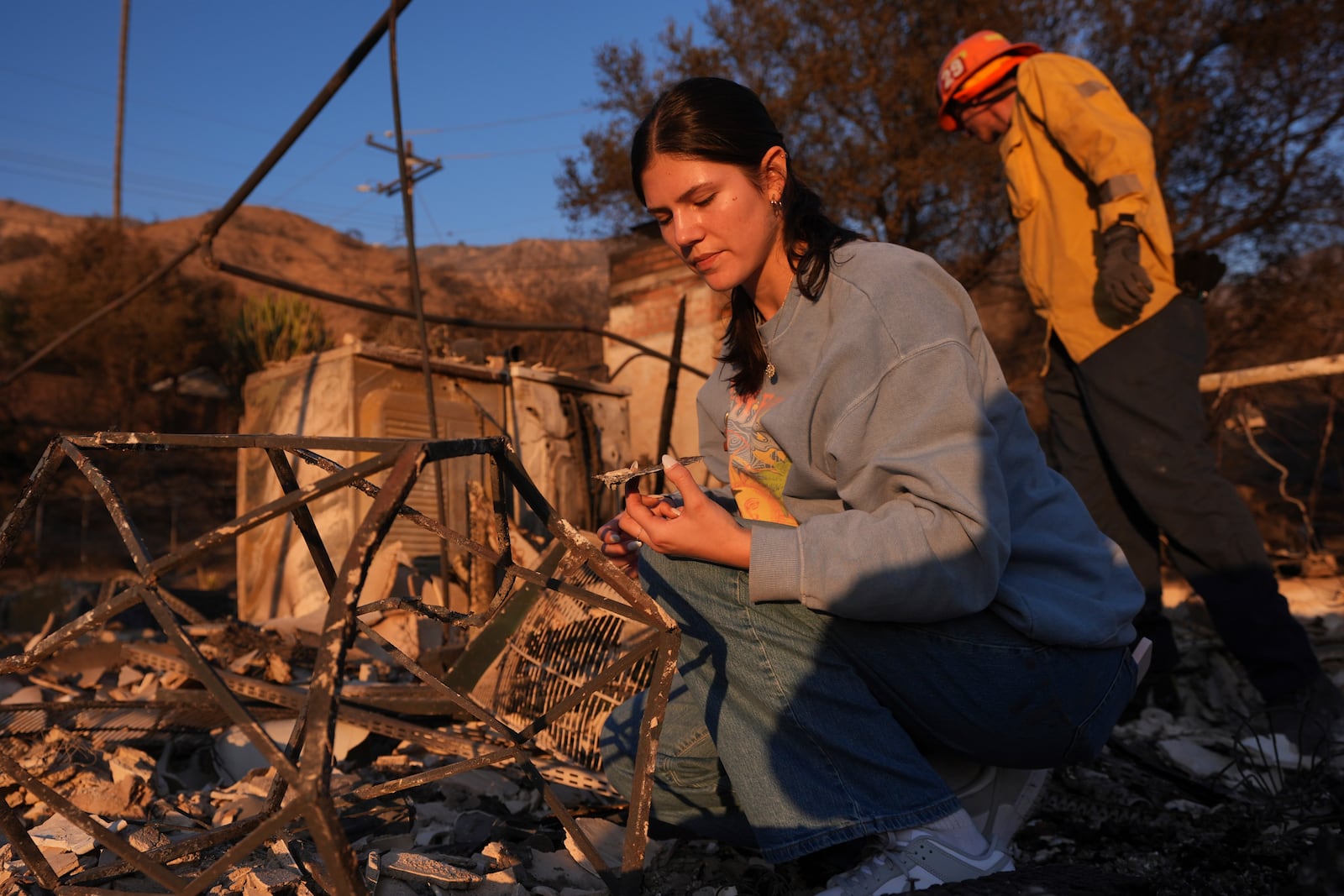 FILE - Ella Venne, left, searches through the remnants of her family's home destroyed by the Eaton Fire in Altadena, Calif., Saturday, Jan. 11, 2025. (AP Photo/Mark J. Terrill, File)