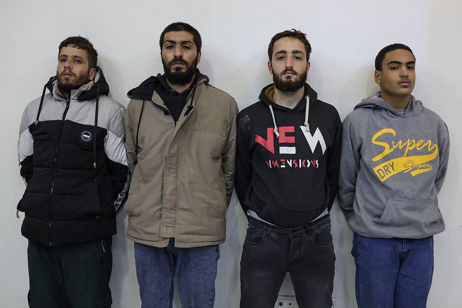 In this photo released by Syrian State TV, four suspects arrested in connection with an alleged plot by ISIS are shown standing against a wall in Damascus, Syria, Saturday, Jan. 11, 2025. Syrian intelligence officials, operating under the country's new de facto government, thwarted an attempt by ISIS to detonate a bomb at the Shiite shrine of Sayyida Zaynab in the Damascus suburb, according to state media reports on Saturday.(Syrian State TV via AP)