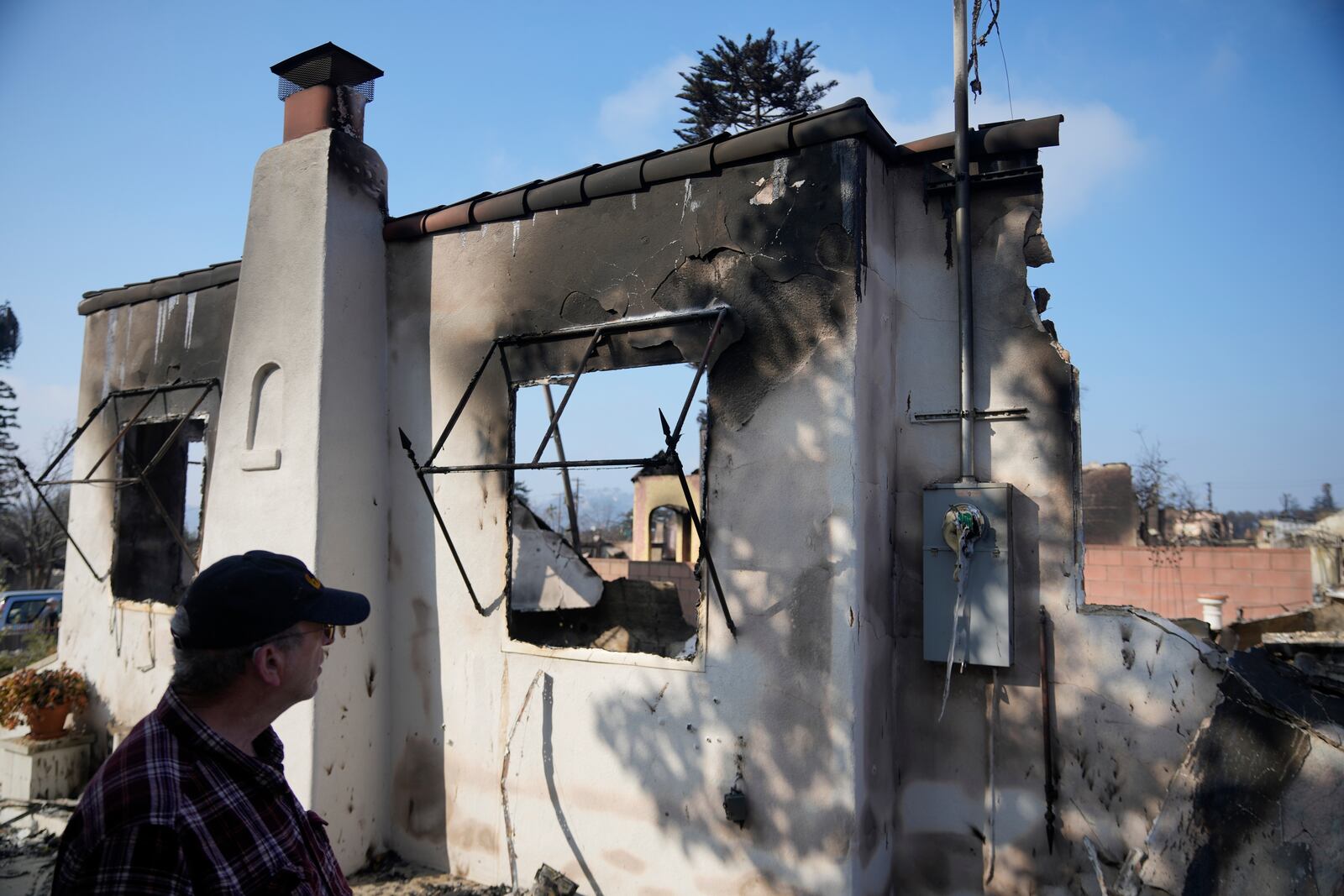 Joel Parkes, a teacher at Los Angeles Unified School District returns to his destroyed home in the aftermath of the Eaton Fire, Sunday, Jan. 19, 2025, in Altadena, Calif. (AP Photo/Damian Dovarganes)