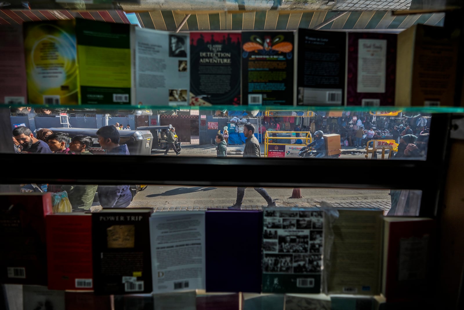 People walk outside a book shop in Srinagar, Indian controlled Kashmir, Monday, Feb.17, 2025. (AP Photo/Mukhtar Khan)