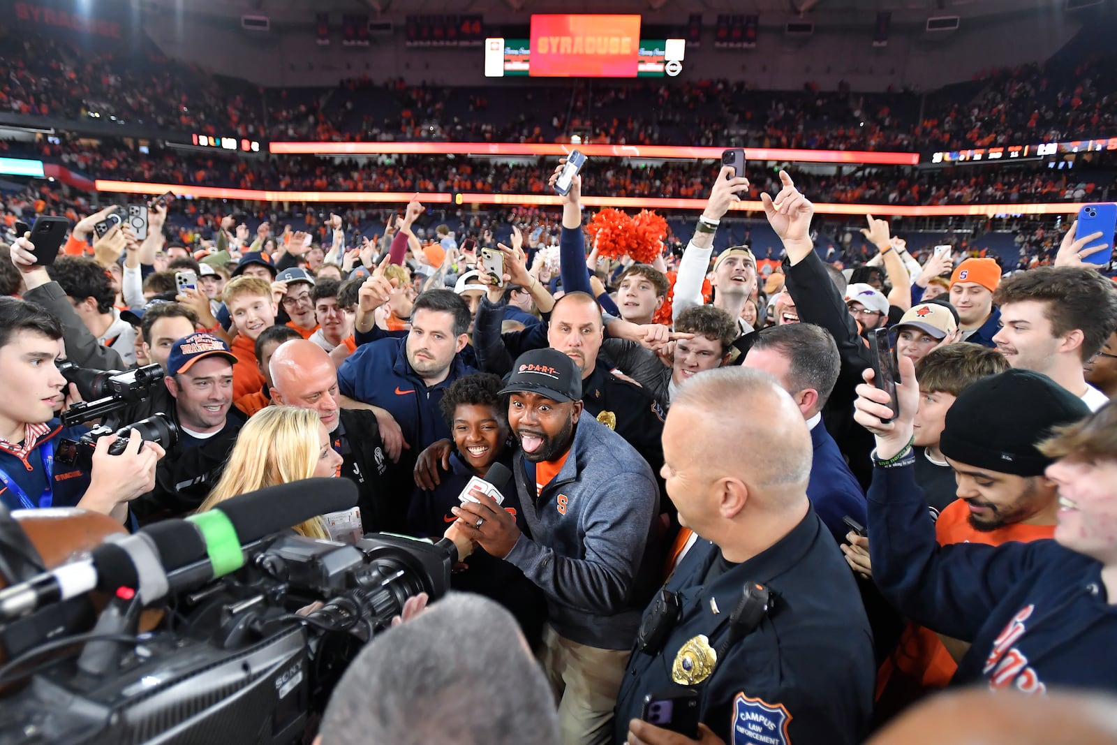 Syracuse head coach Fran Brown, center, reacts while being interviewed after his team's win over Miami in an NCAA college football game Saturday, Nov. 30, 2024, in Syracuse, N.Y. (AP Photo/Adrian Kraus)