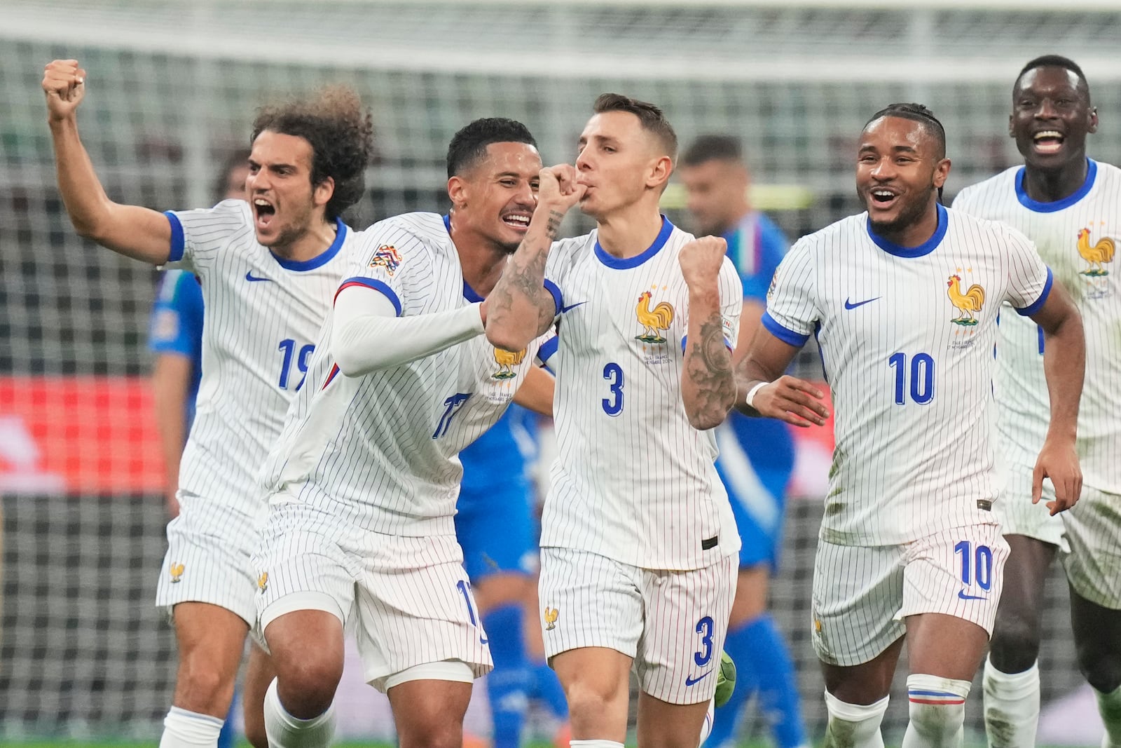 France's Lucas Digne, centre, celebrates with teammates after Italy goalkeeper Guglielmo Vicario scored the own goal during the Nations League soccer match between Italy and France, at the San Siro stadium in Milan, Italy, Sunday, Nov. 17, 2024. (AP Photo/Luca Bruno)