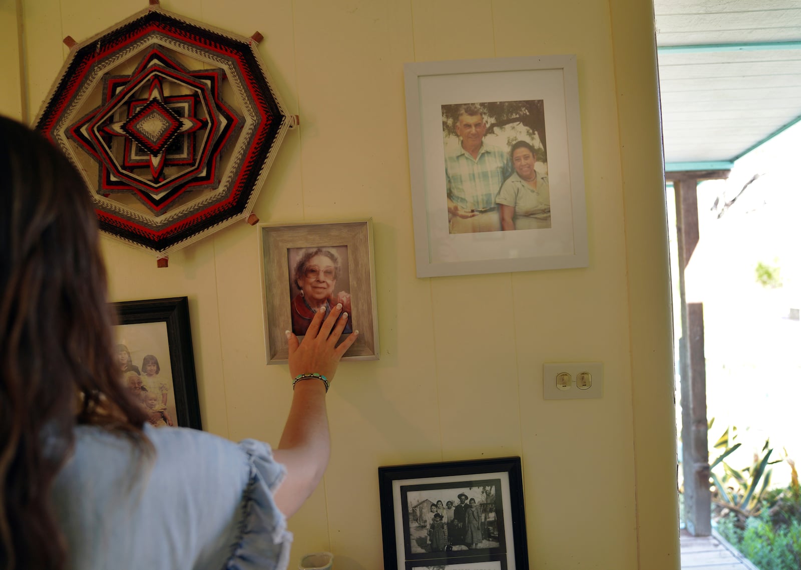 Photos of the late Amada Cardenas and her husband, who were the first federally licensed peyote dealers to harvest and sell the sacramental plant to followers of the Native American Church, hang in her home in Mirando City, Texas, Monday, March 25, 2024. (AP Photo/Jessie Wardarski)