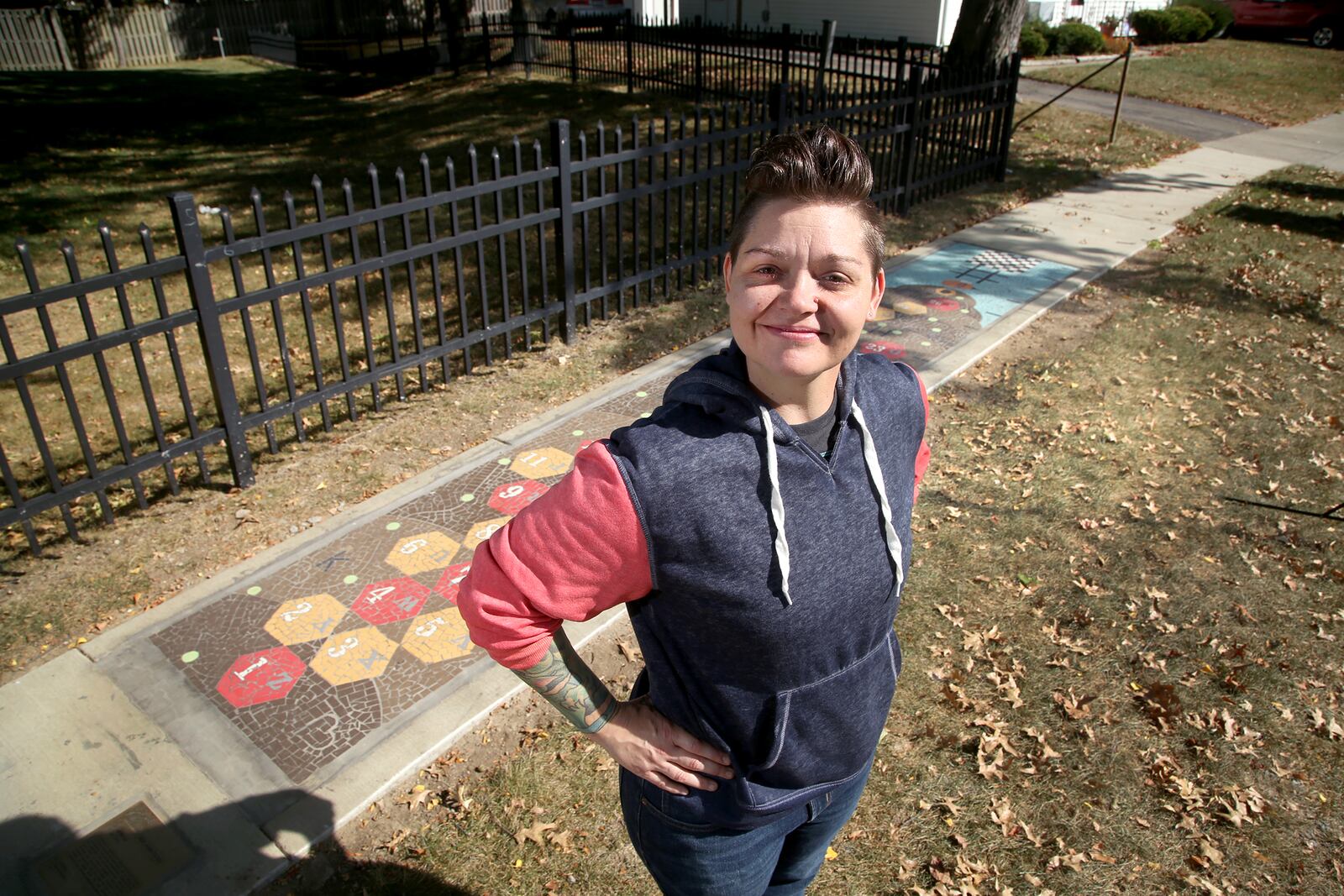 Jes McMillan, founder of The Mosaic Institute of Greater Dayton, spearheaded the creation of "Bee Ambitious," a public artwork that is also a series of interactive games,  in Kettering's Haverstick neighborhood. LISA POWELL / STAFF