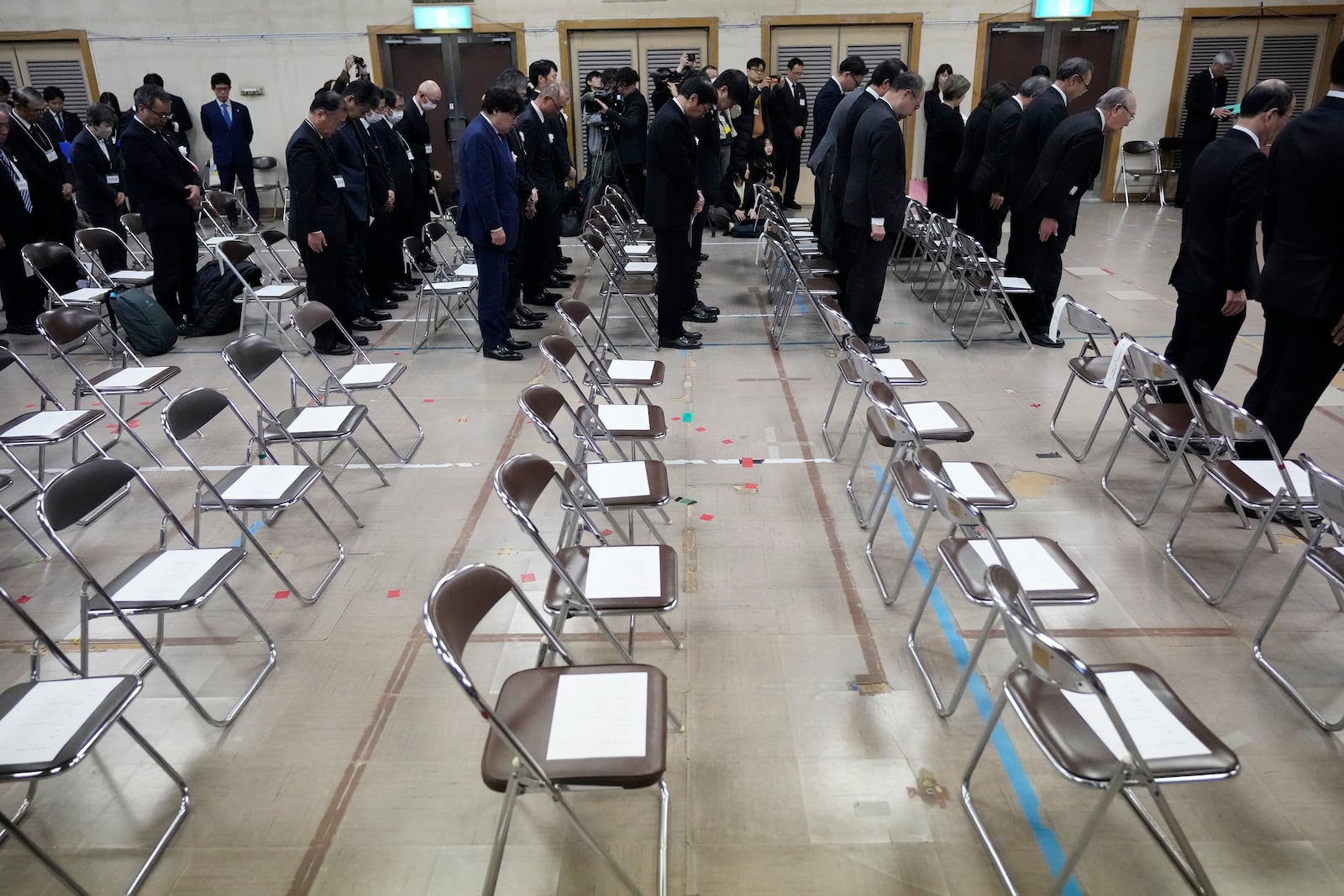 Guests offer a moment of silence during a memorial ceremony for the Sado Island Gold Mine in Sado, Niigata prefecture, Japan, as several seats reserved for South Korean guests remained empty Sunday, Nov. 24, 2024. (AP Photo/Eugene Hoshiko)