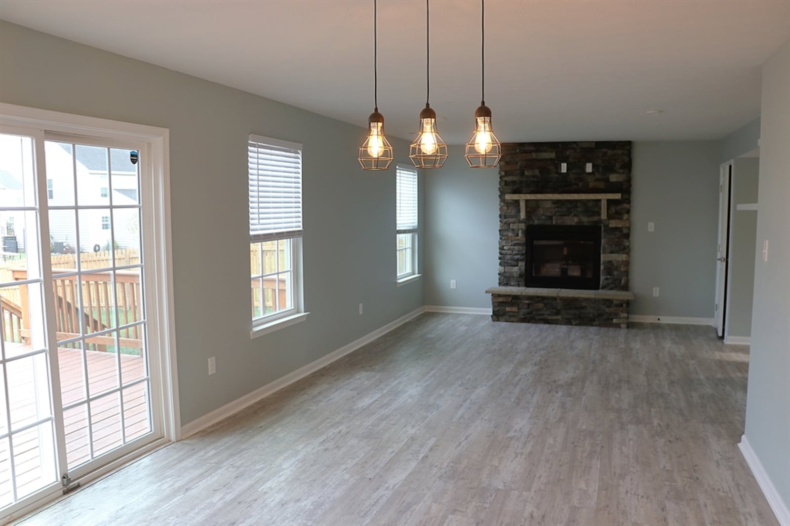 A stack-stone gas fireplace has a raised stone hearth and a stone mantel and is the centerpiece to the living room.