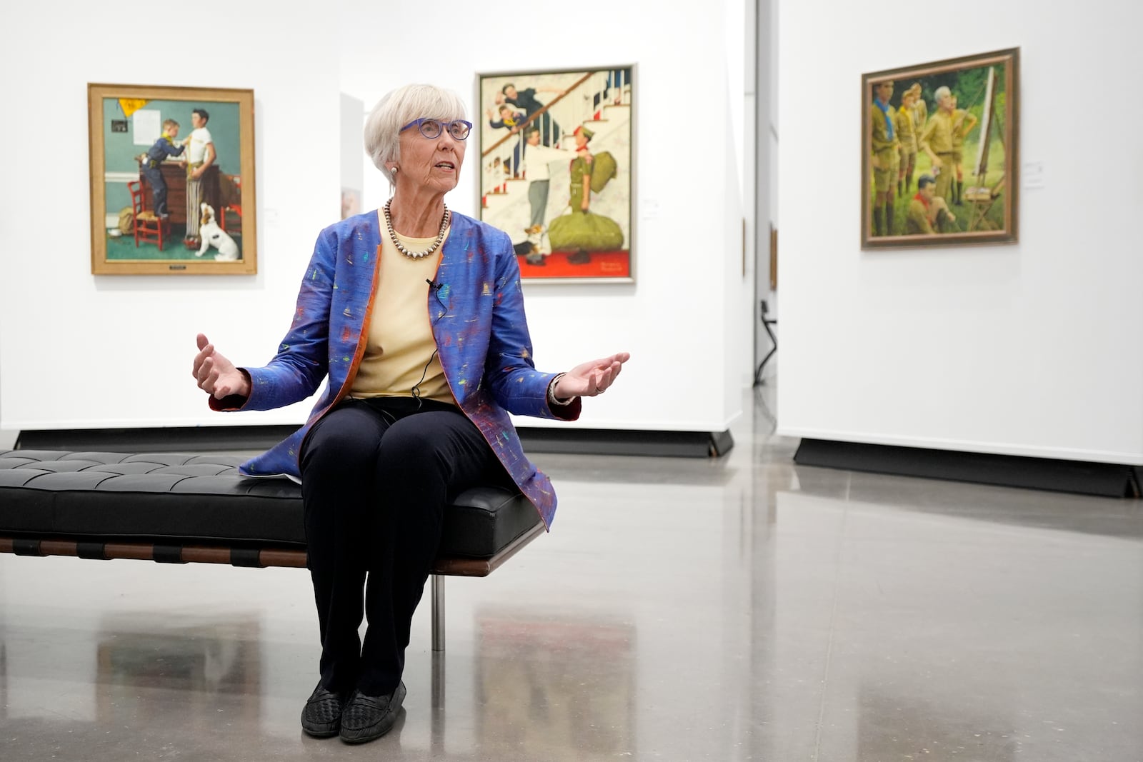 Judge Barbara Houser responds to a question during an interview at Heritage Auctions in Dallas, Thursday, Oct. 17, 2024, as she sits by a collection of paintings from the Boy Scouts of America's storied collection that will be going up for auction. (AP Photo/Tony Gutierrez)