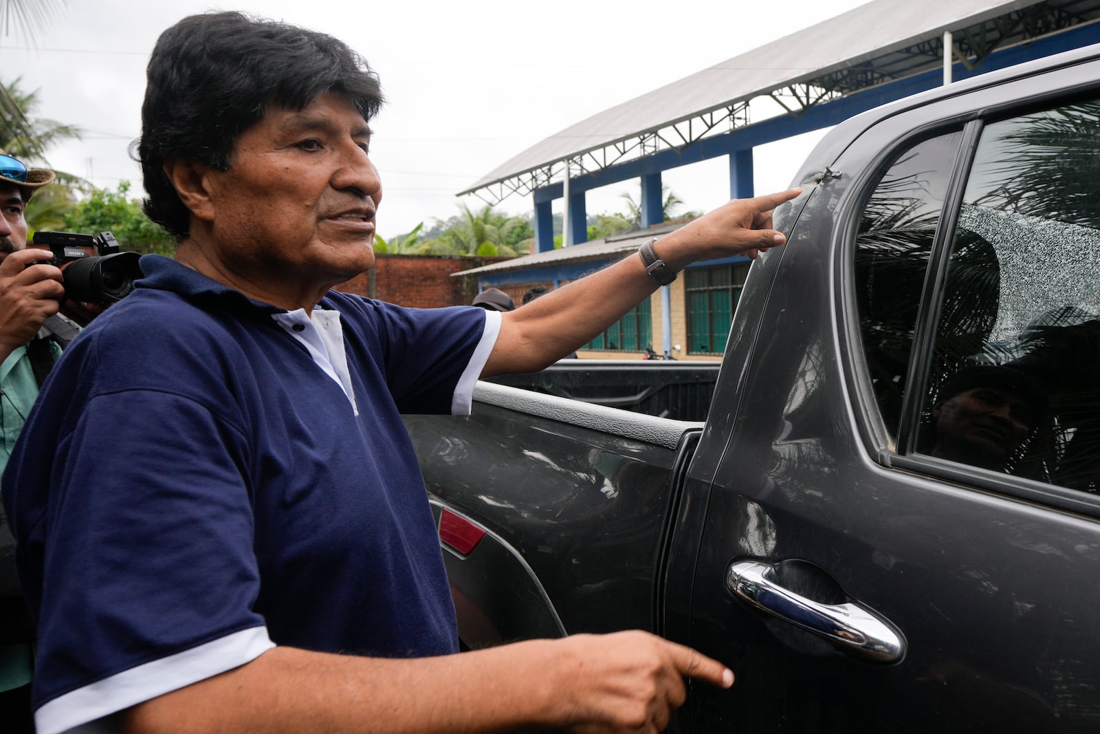 Former Bolivia's President Evo Morales points to a bullet hole on his car that he claims was the result of an assassination attempt, in Lauca N, Chapare region, Bolivia, Sunday, Nov. 3, 2024, amid an ongoing political conflict with the government of President Luis Arce. (AP Photo/Juan Karita)