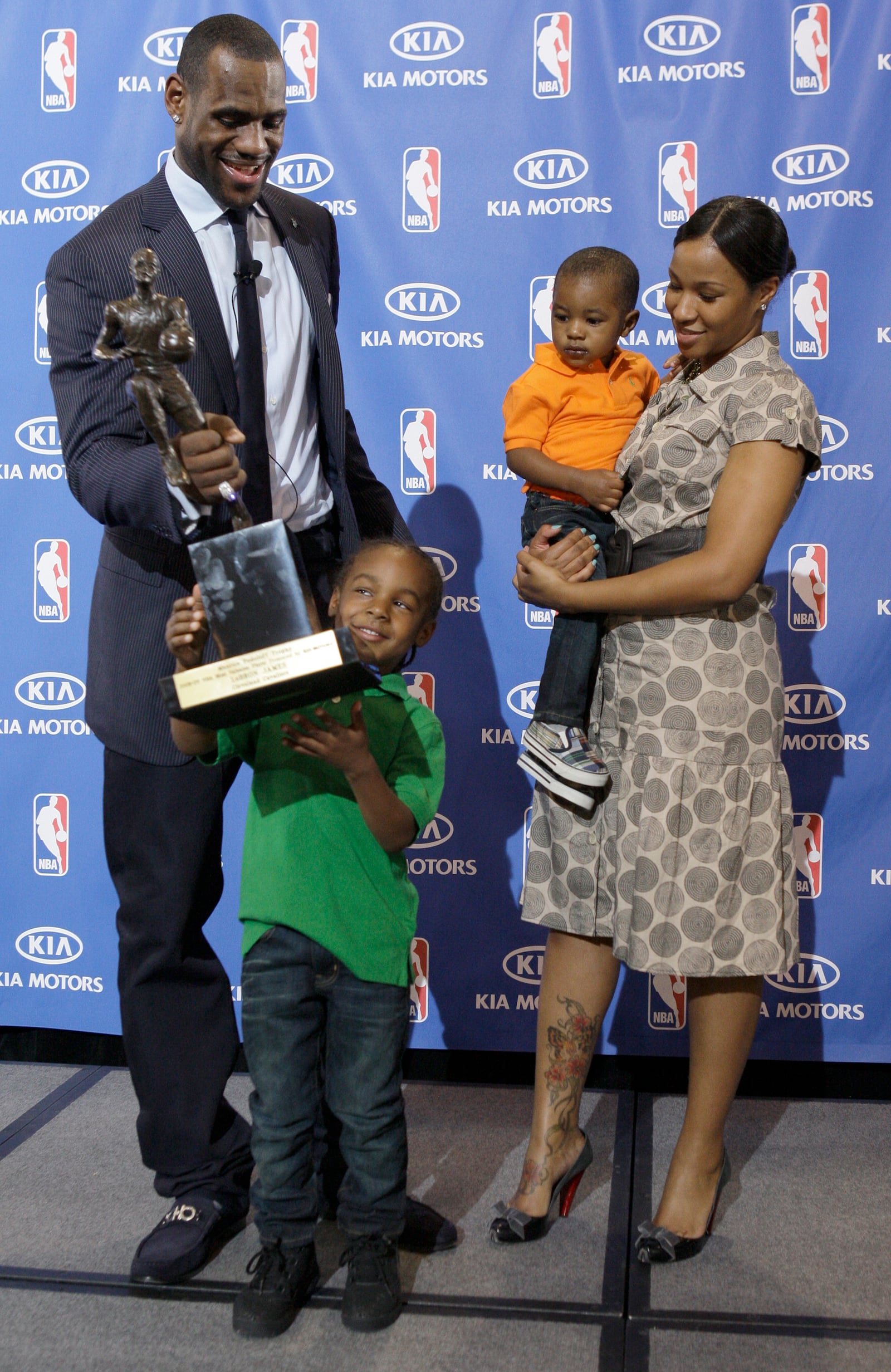 FILE - After accepting the NBA Most Valuable Player award during a ceremony at James' alma mater, Akron St. Vincent-St. Mary High School, in Akron, Ohio, Monday, May 4, 2009, Cleveland Cavaliers LeBron James hands the trophy to his son Lebron Jr., 4, as James girlfriend Savannah Brinson and their youngest son Bryce look on. (AP Photo/Amy Sancetta, File)