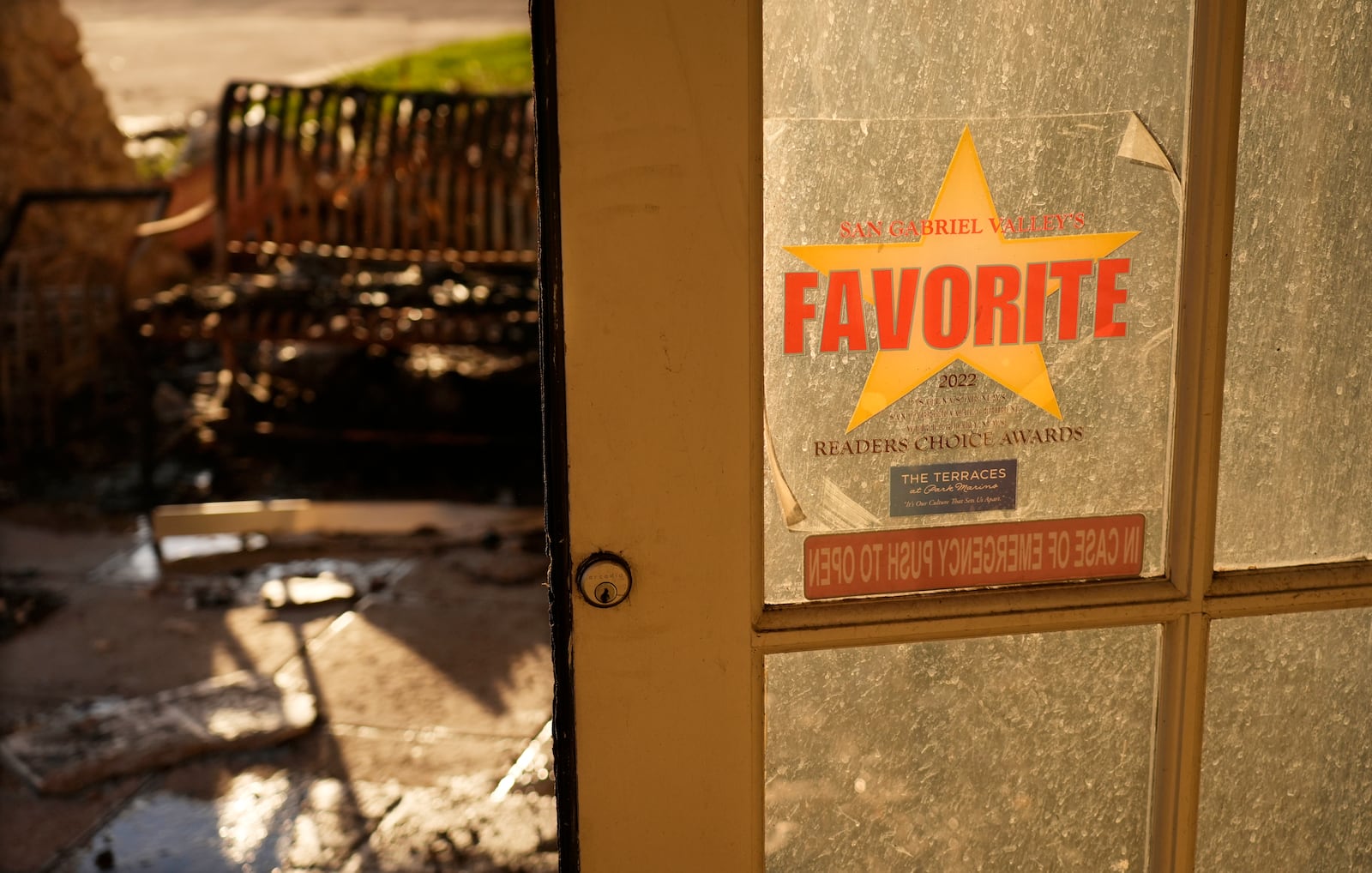 A decal advertising a Readers' Choice Award for the Terraces at Park Marino assisted living facility from a local newspaper is seen on a door near the charred remains of the structure on Monday, Jan. 13, 2025, in Pasadena, Calif. (AP Photo/Chris Pizzello)