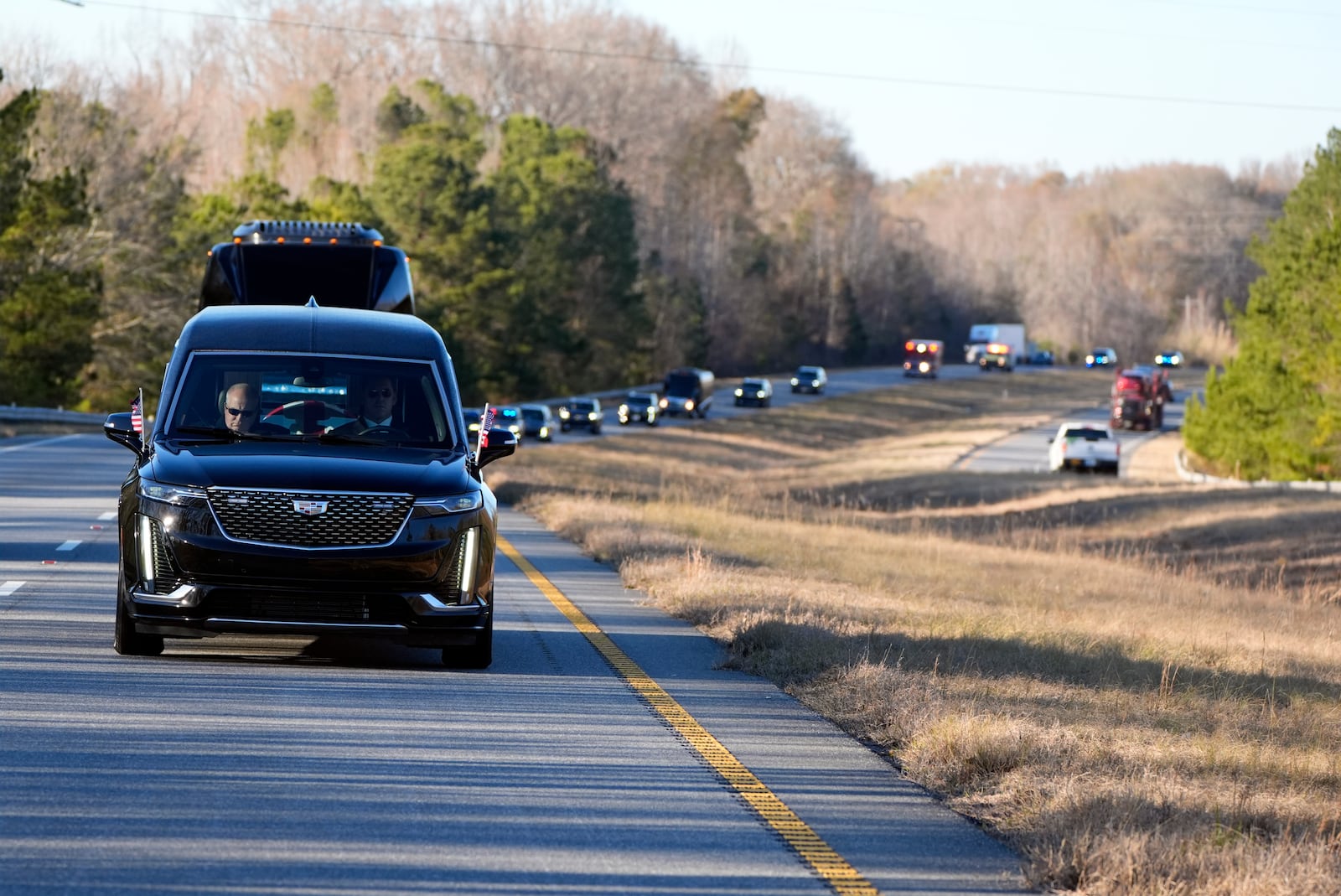 The hearse containing the flag-draped casket of former President Jimmy Carter travels in the motorcade from Lawson Army Airfield, in Fort Moore, Ga., to Maranatha Baptist Church in Plains, Ga., Thursday, Jan. 9, 2025. (AP Photo/Alex Brandon, Pool)