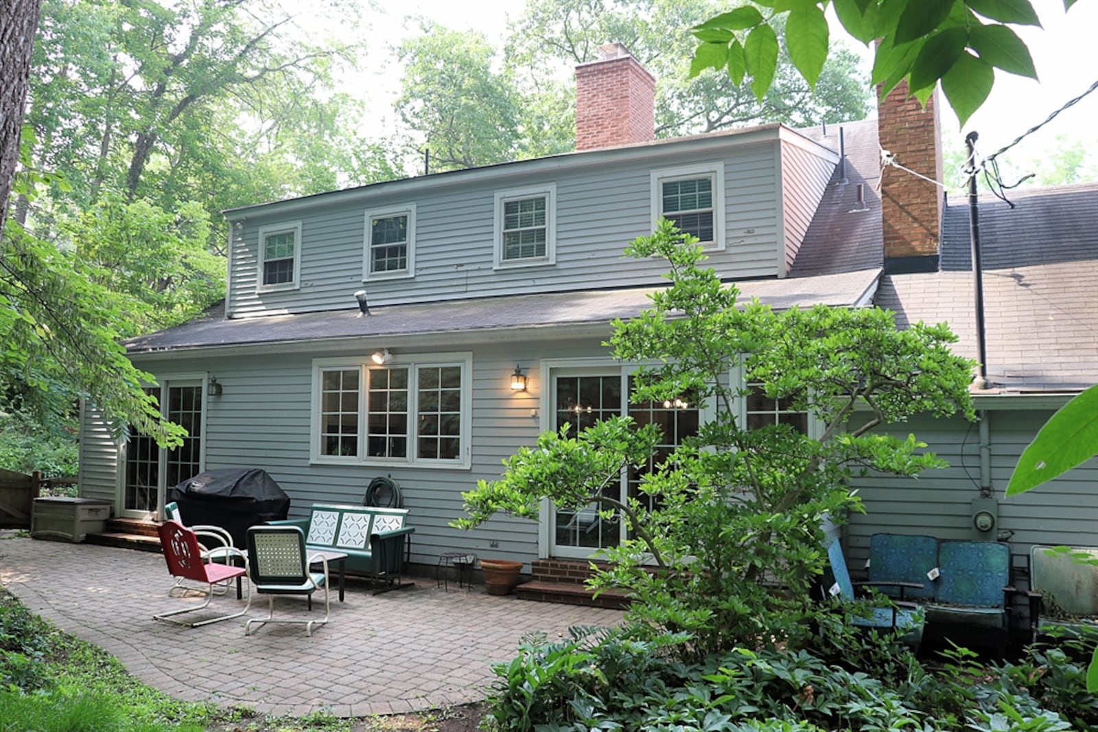 Sliding patio doors open from the hearth room out to the backyard paver patio and private wooded yard.