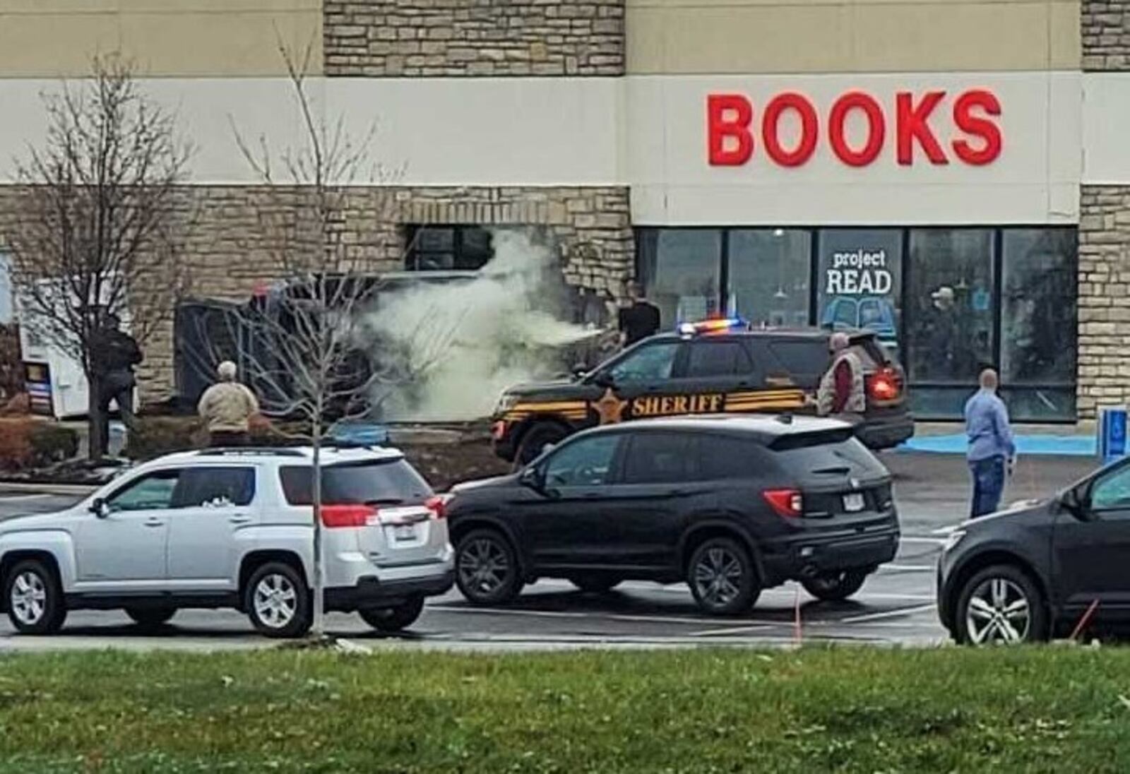 Smoke is shown after a vehicle ran through a parking lot and struck a bookstore in Washington Twp. on Thursday, Dec. 17, 2020. DARIUS BABCOCK/STAFF