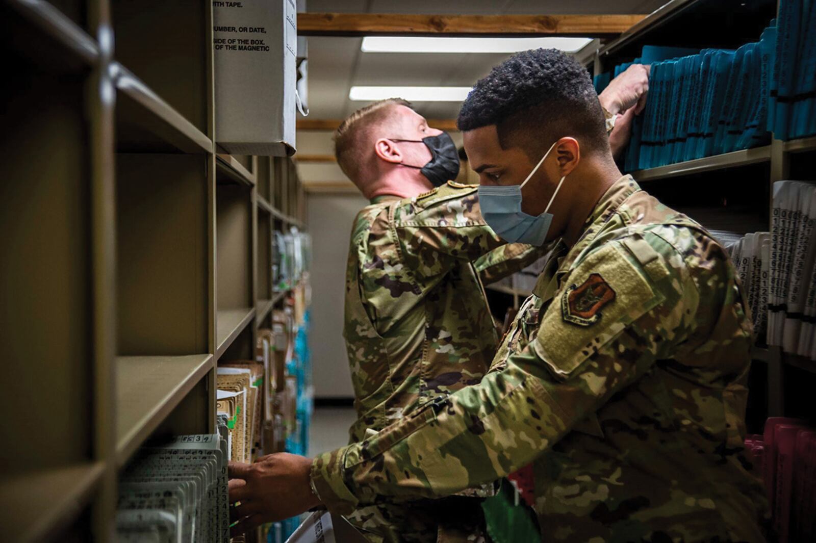 Staff Sgt. Ramello Rhodes (front) and Senior Airman Ryan Faris, both assigned to the 445th Aeromedical Staging Squadron, sort through patient records at Naval Medical Center San Diego March 16. NAVY PHOTO/PETTY OFFICER 2ND CLASS LUKE CUNNINGHAM