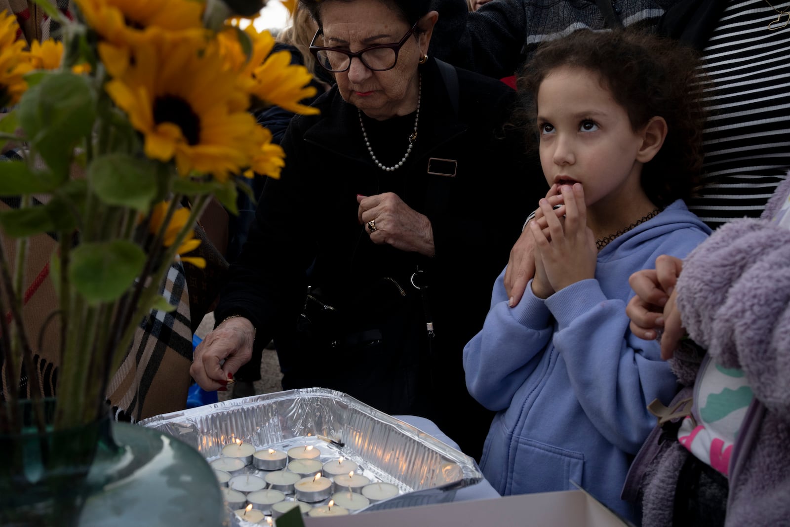 People gather to light candles for Shabbat in Tel Aviv, Israel, after Israel's security Cabinet recommended approval of a ceasefire deal after Prime Minister Benjamin Netanyahu confirmed an agreement had been reached that would pause the 15-month war with Hamas in Gaza and release dozens of hostages held by militants there, Friday, Jan. 17, 2025. (AP Photo/Maya Alleruzzo)