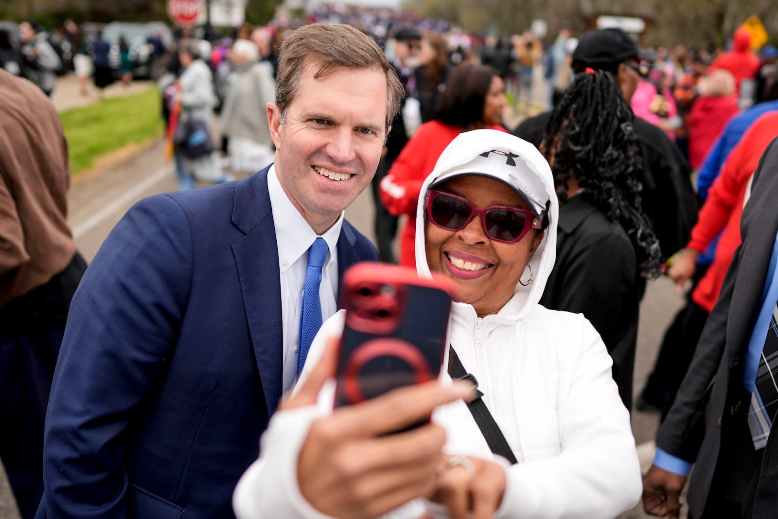 Kentucky Gov. Andy Beshear takes a photo with a marcher during the 60th anniversary of the march to ensure that African Americans could exercise their constitutional right to vote, Sunday, March 9, 2025, in Selma, Ala. (AP Photo/Mike Stewart)